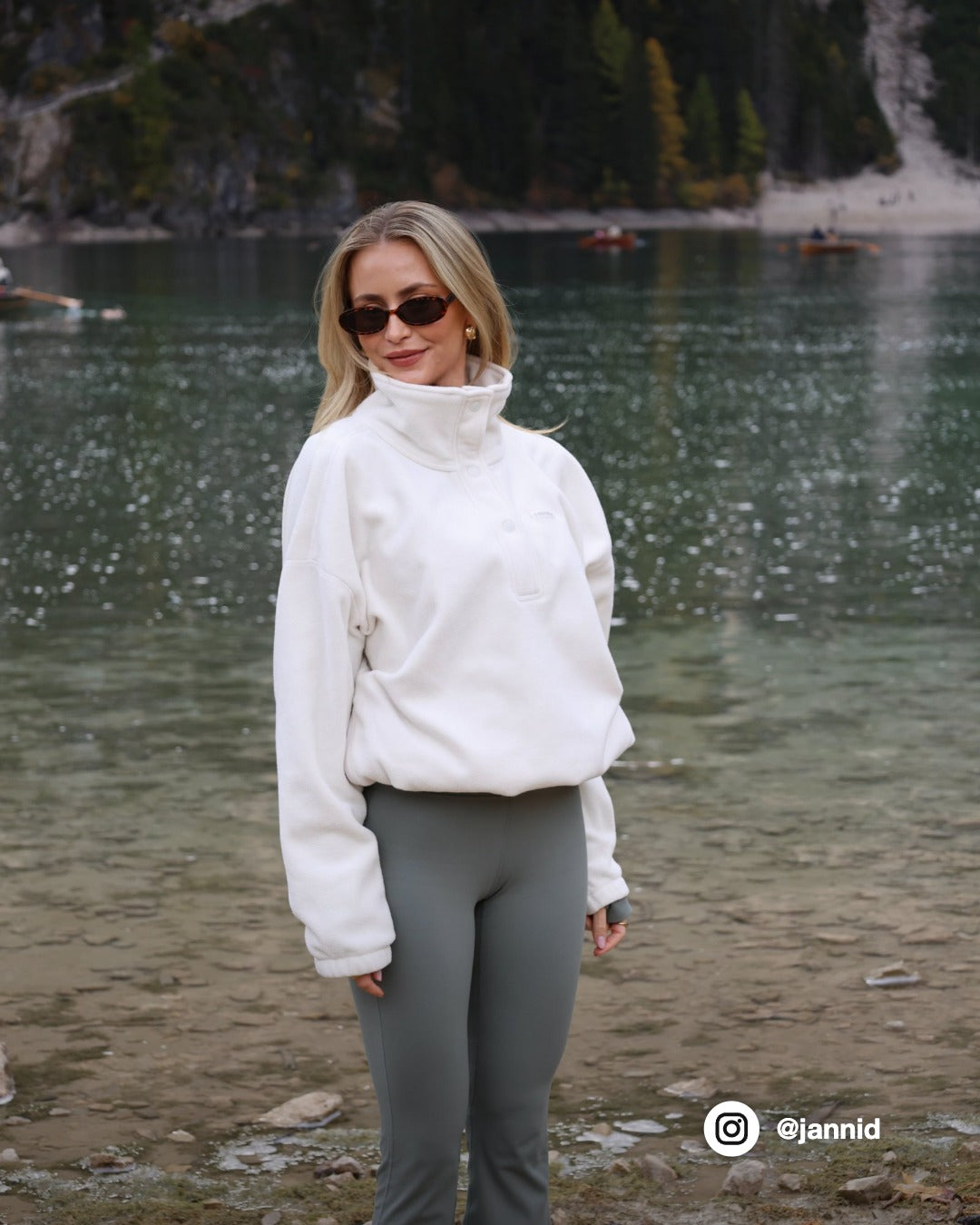Woman wearing a creme CASPARA polar fleece half-snap pullover standing by a lake.