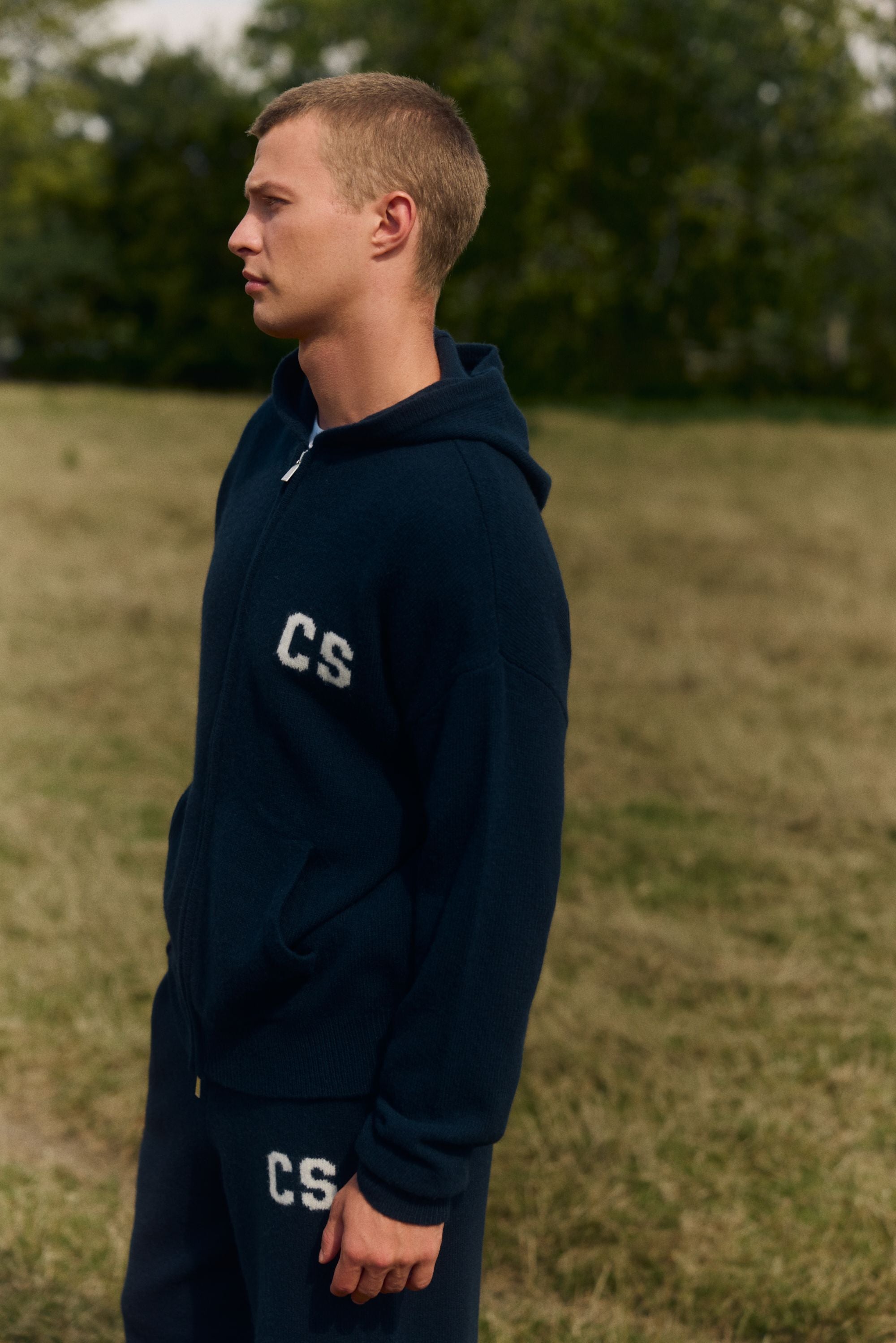 Man wearing a navy CASPARA woolknit zip jacket in a grassy field.