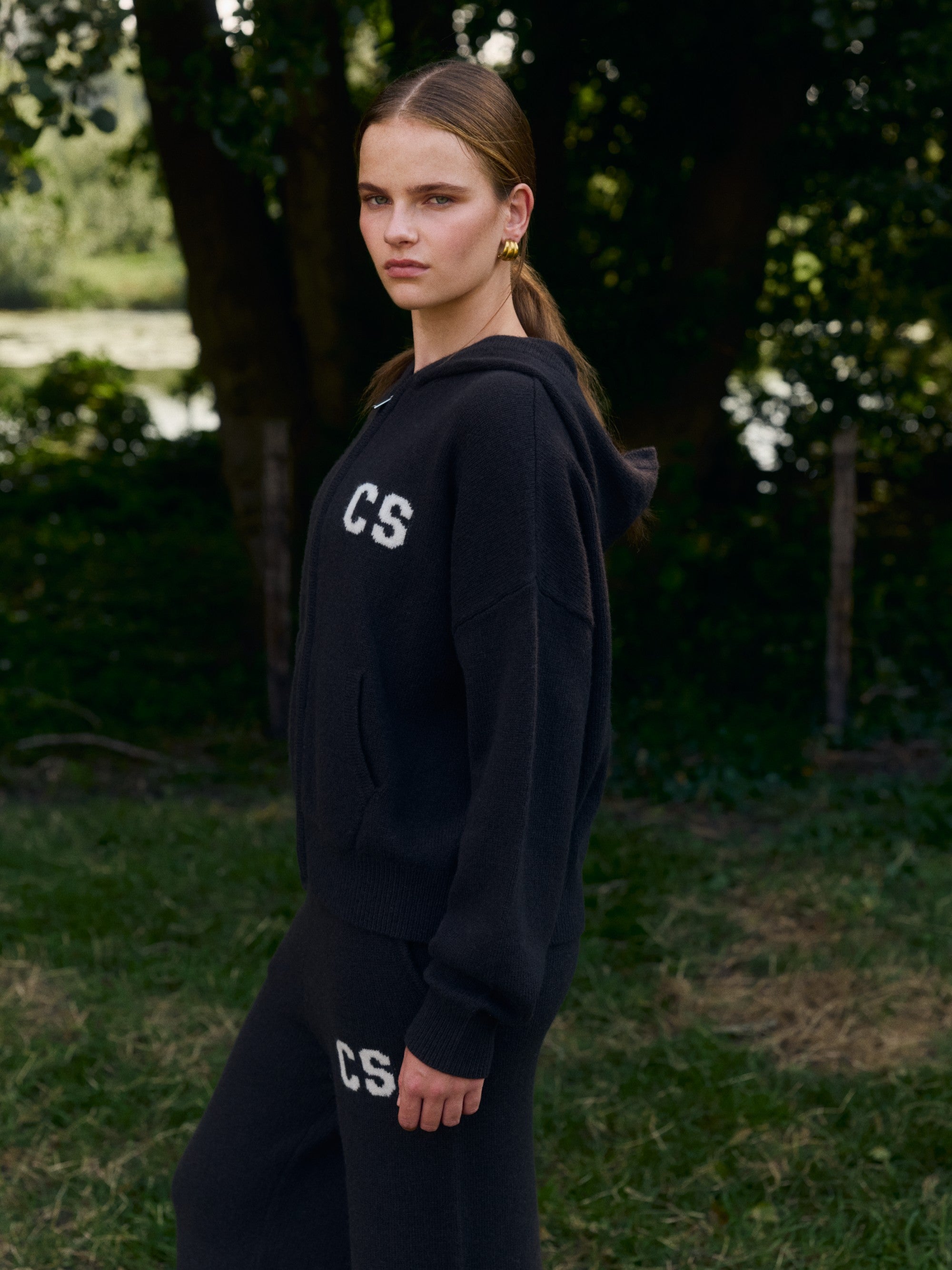 Woman wearing a cocoa bean CASPARA CS woolknit zip jacket and matching pants outdoors.