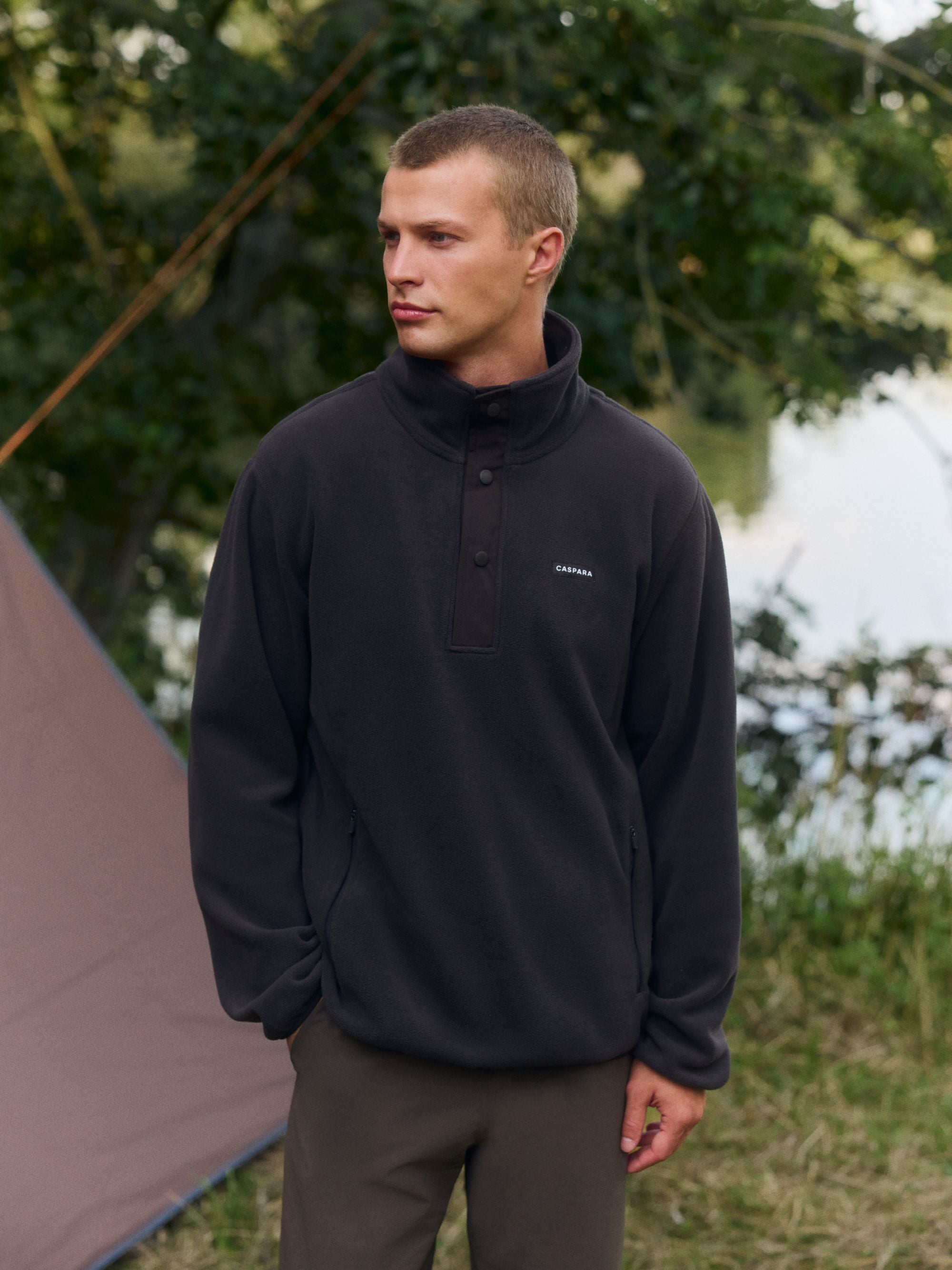 Man wearing a cocoa bean CASPARA polar fleece half-snap pullover outdoors.