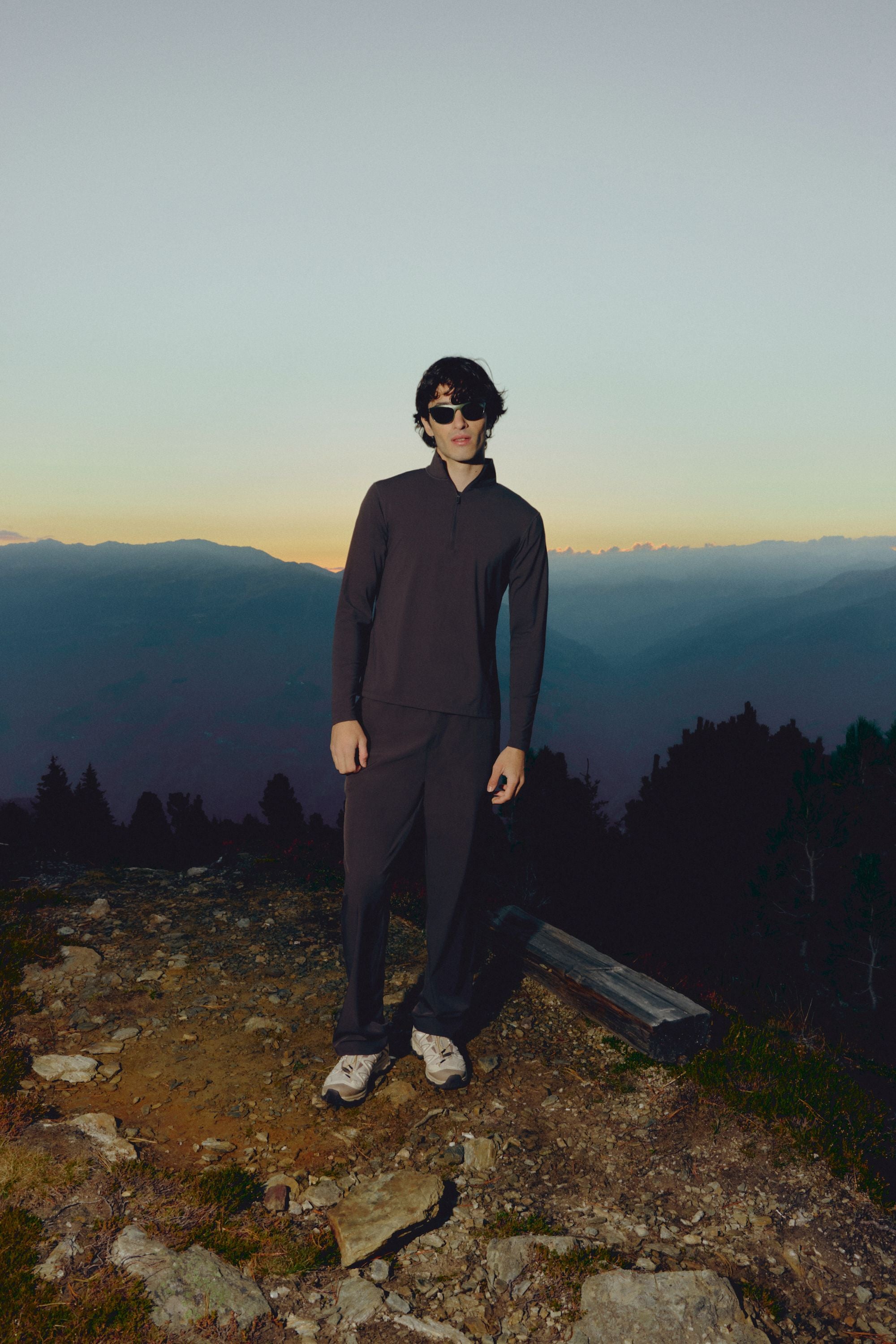 Man wearing an espresso CASPARA Prime Core half zip in a mountain landscape.
