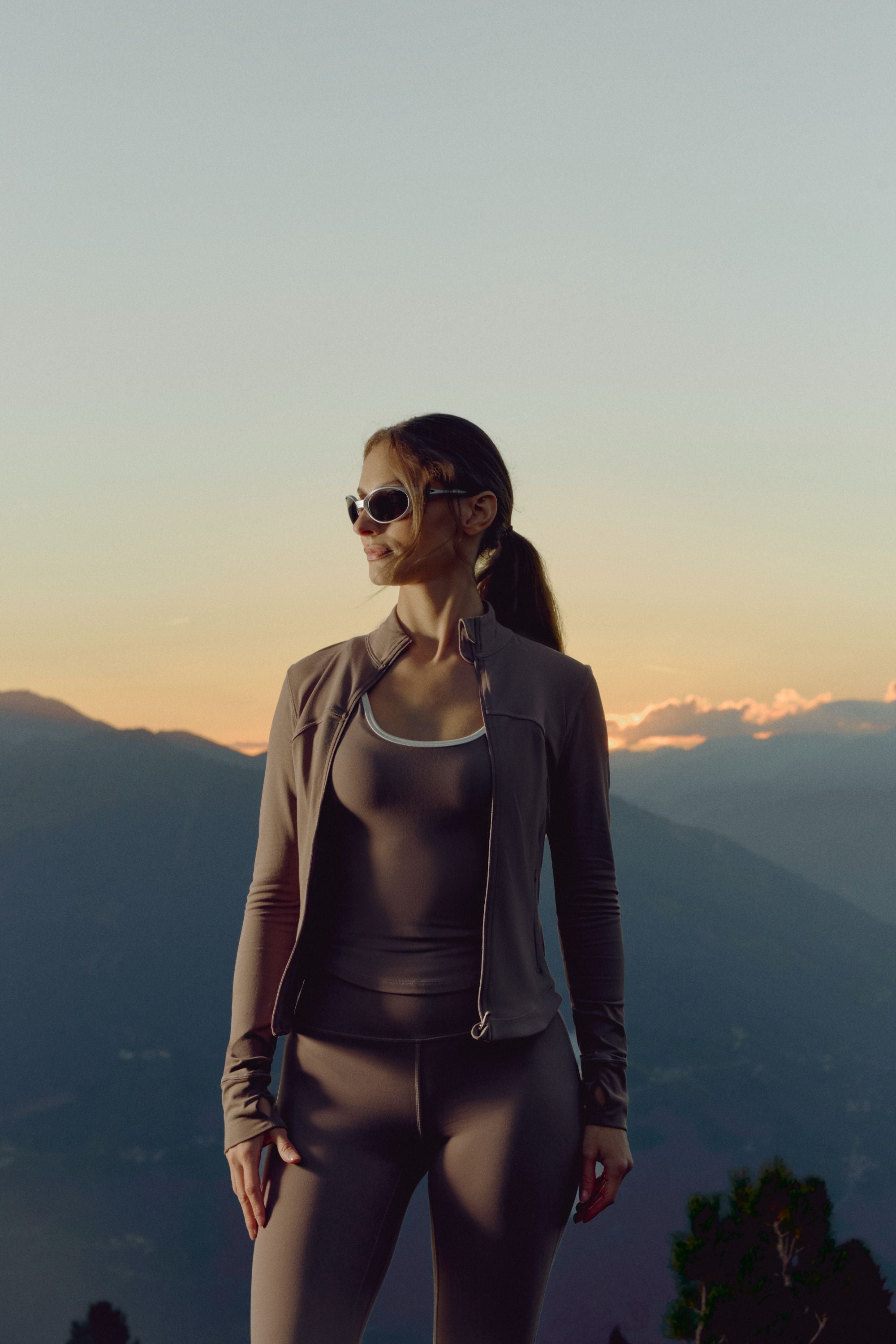Woman wearing a walnut CASPARA Cloudform square neck top in a mountain landscape.