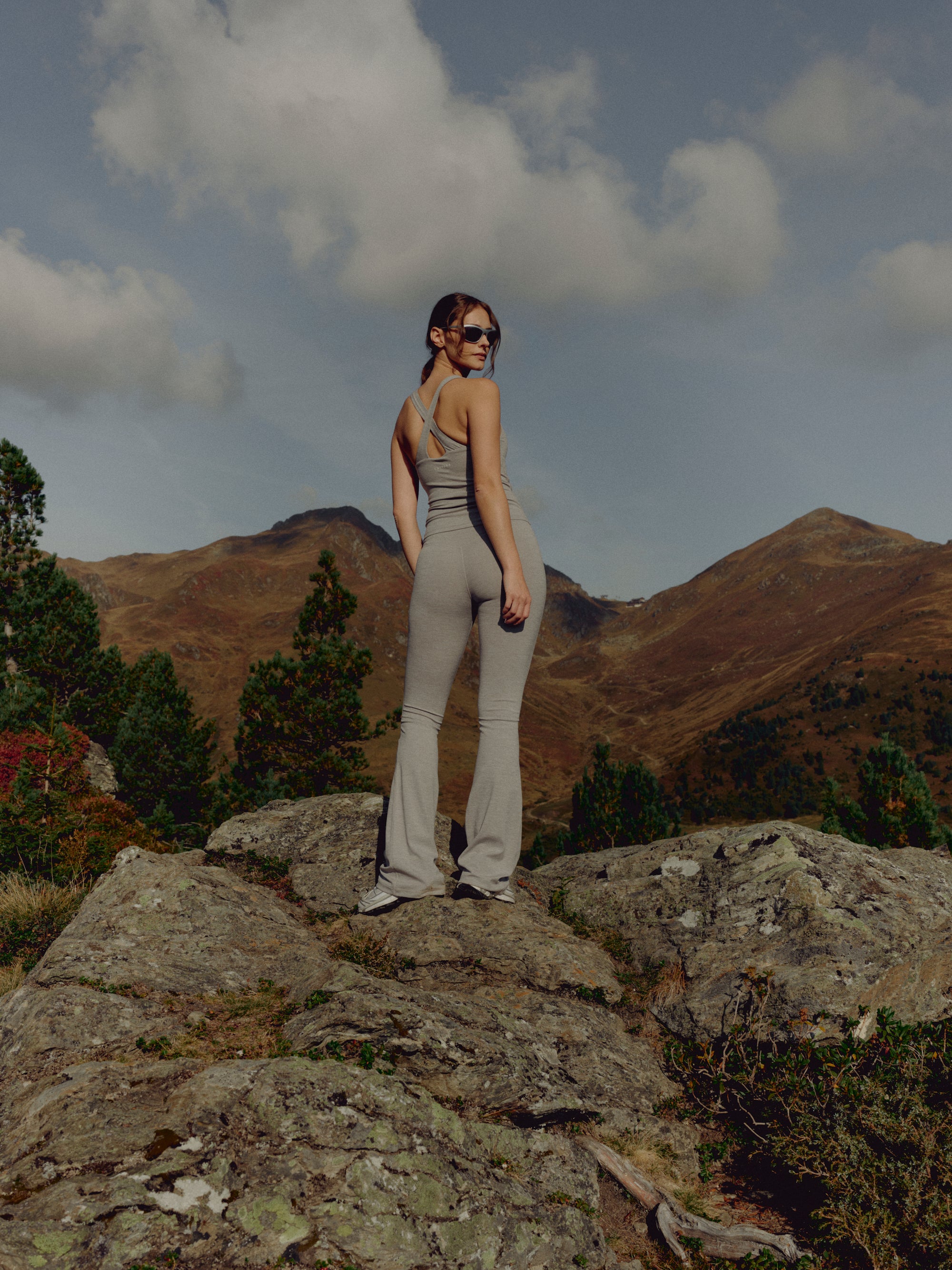Woman wearing grey melange CASPARA Cloudform yoga pants in a mountain landscape.