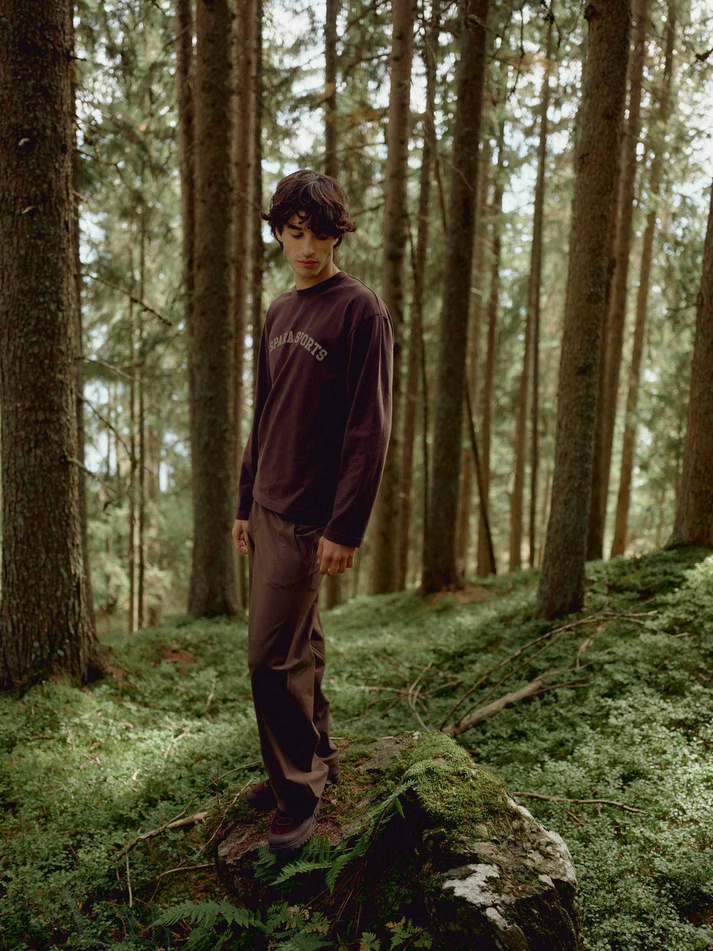 Man wearing an espresso CASPARA CS Signature long sleeve shirt in a pine forest.