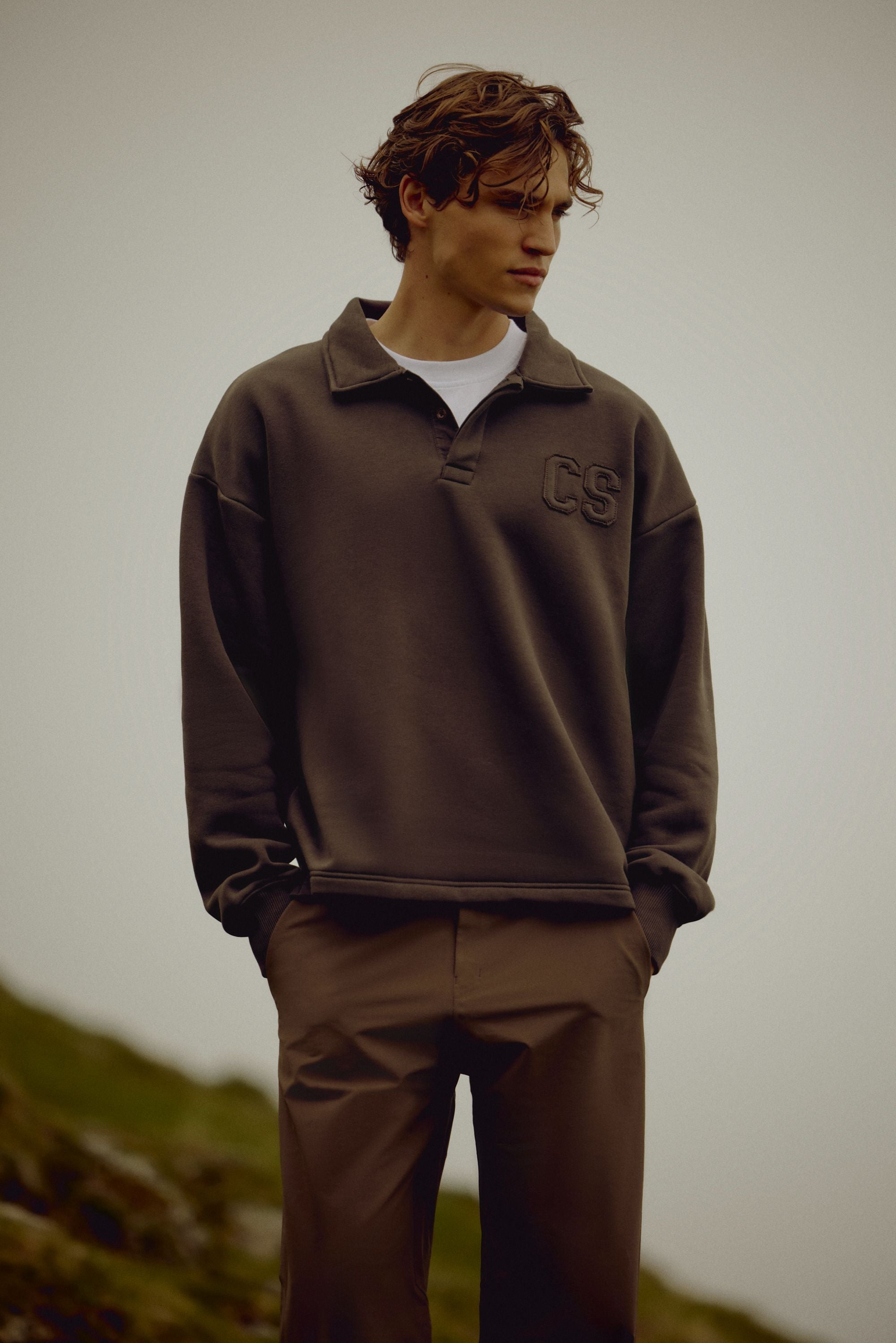 Man wearing an espresso CASPARA CS rugby shirt outdoors.