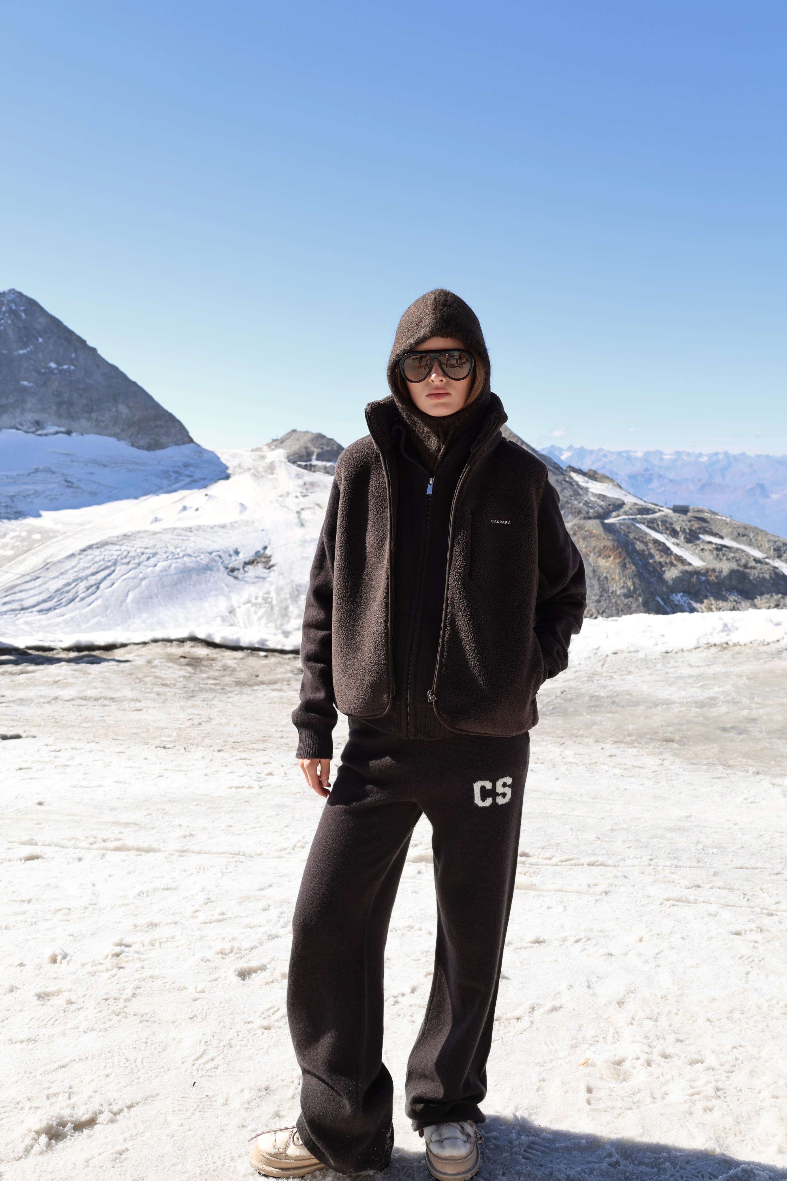 Woman wearing cocoa bean CASPARA woolknit straight leg pants on a snowy mountain.