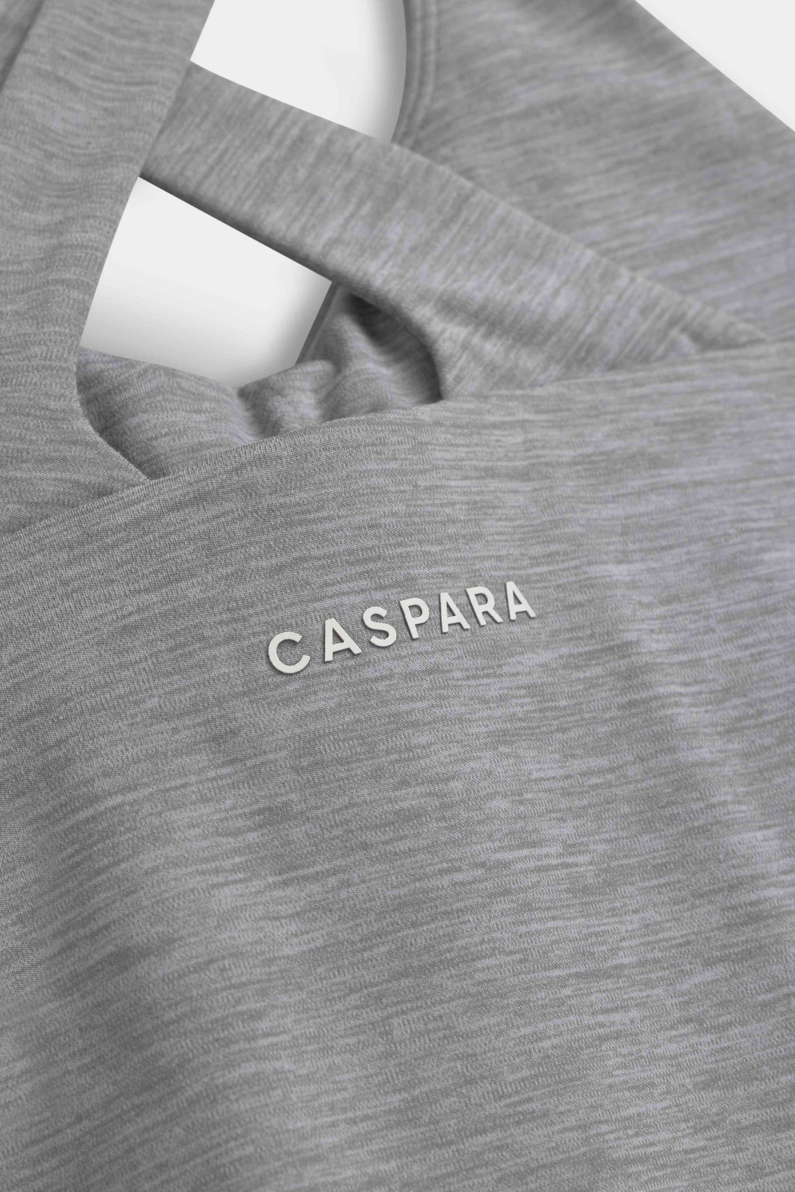 Close-up of the grey melange CASPARA Cloudform top showing the crossback straps and logo.