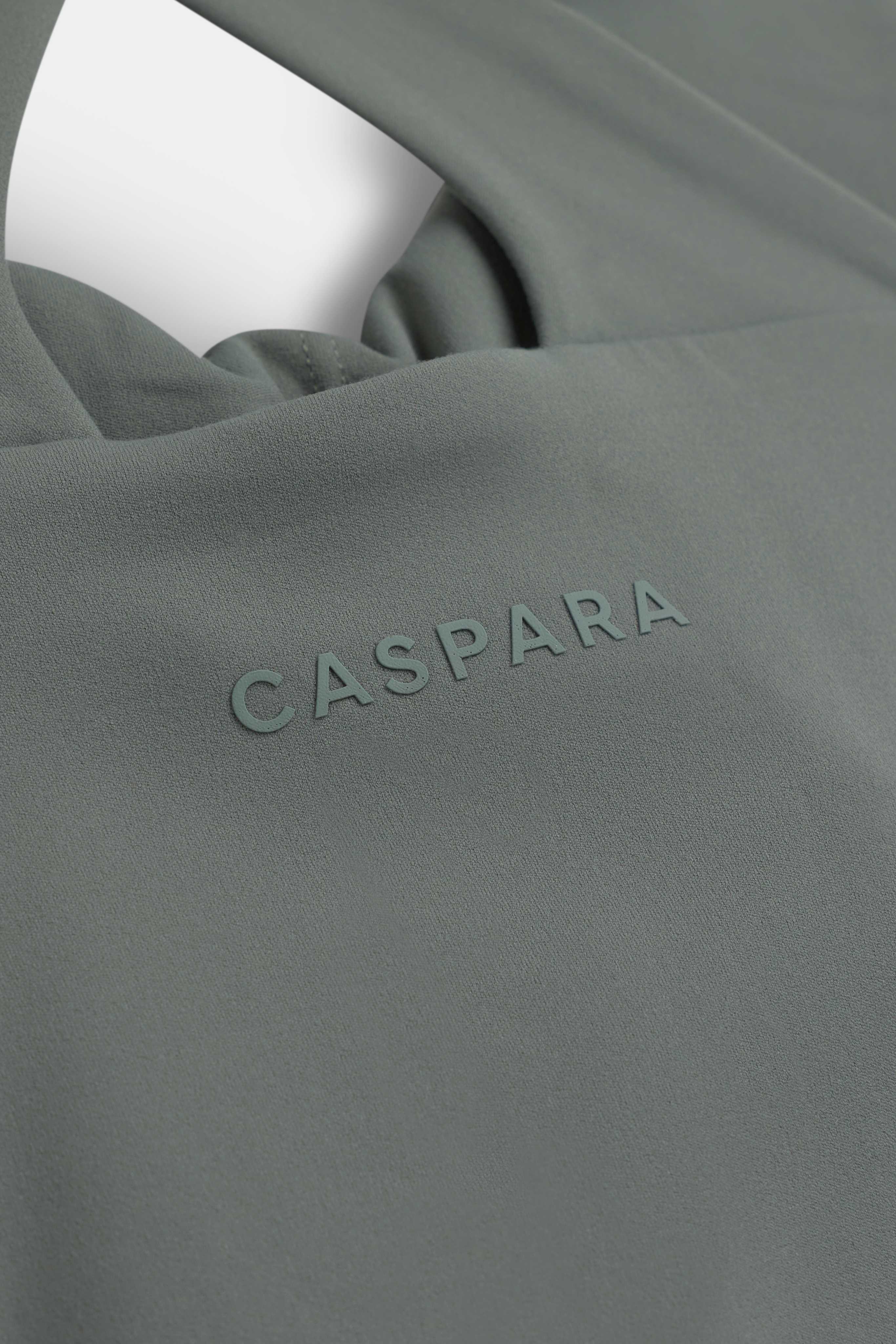 Close-up of the tonal CASPARA logo on the khaki Cloudform® Scrunch Top.