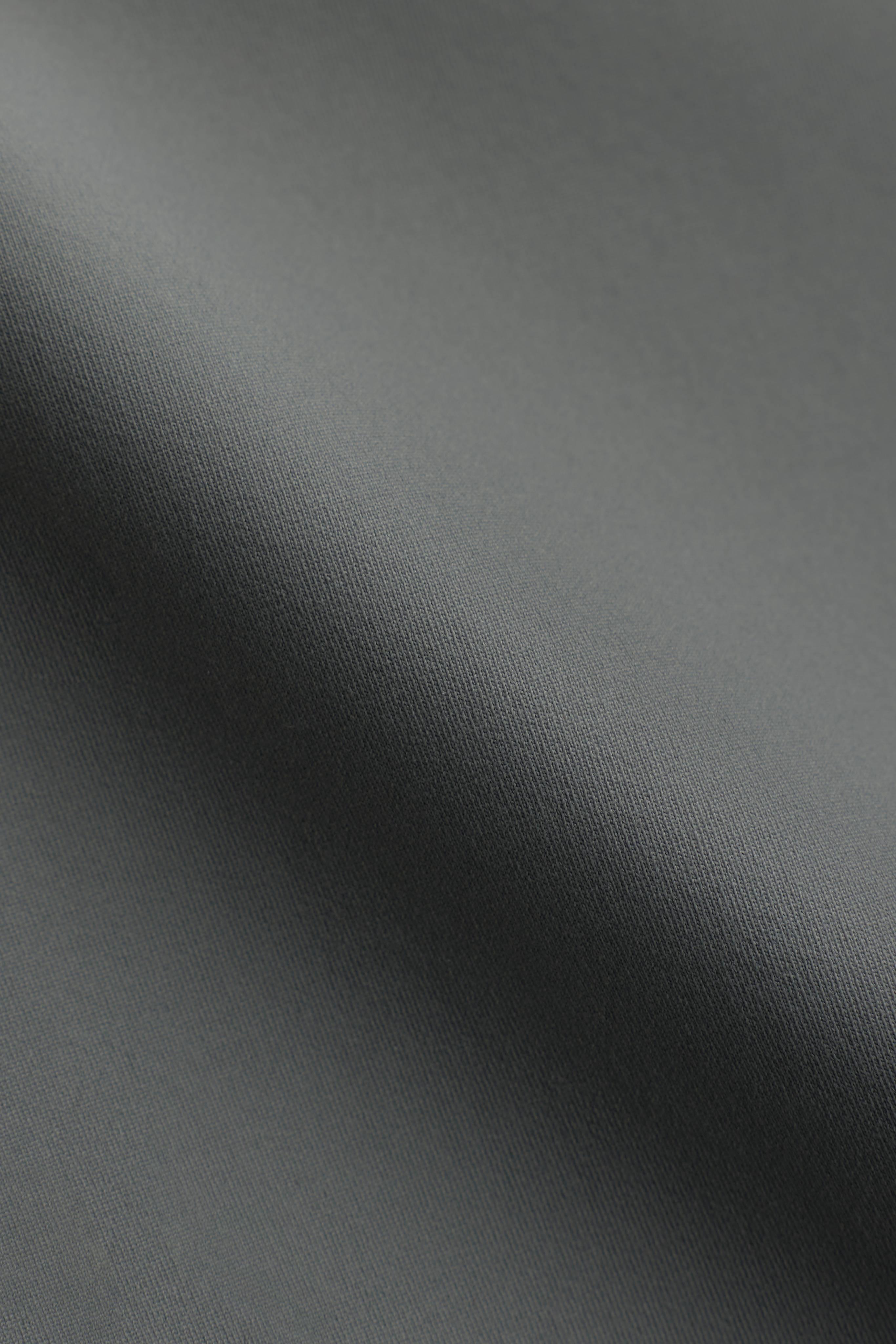 Close-up of the smooth khaki fabric texture on the CASPARA Cloudform® top.