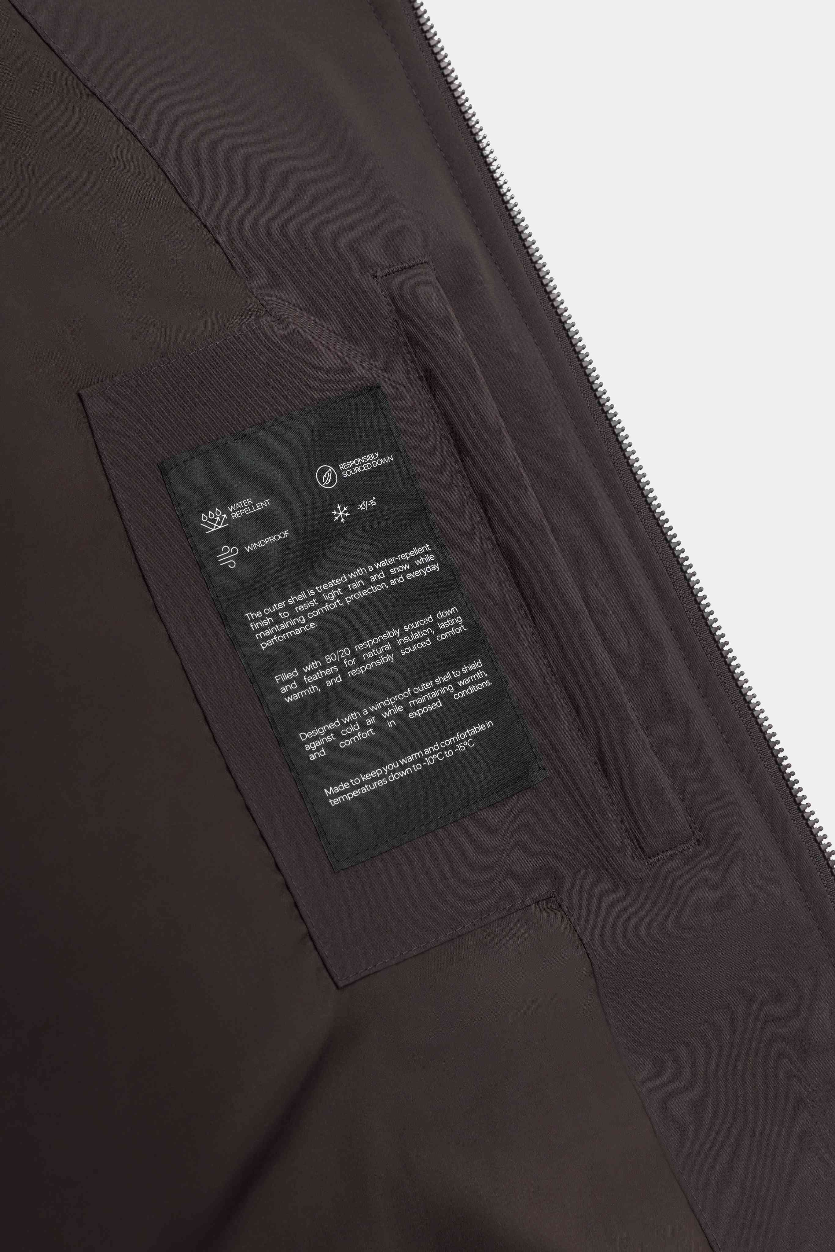 Interior feature label and inner pocket on the cocoa bean CASPARA Boreal puffer jacket.