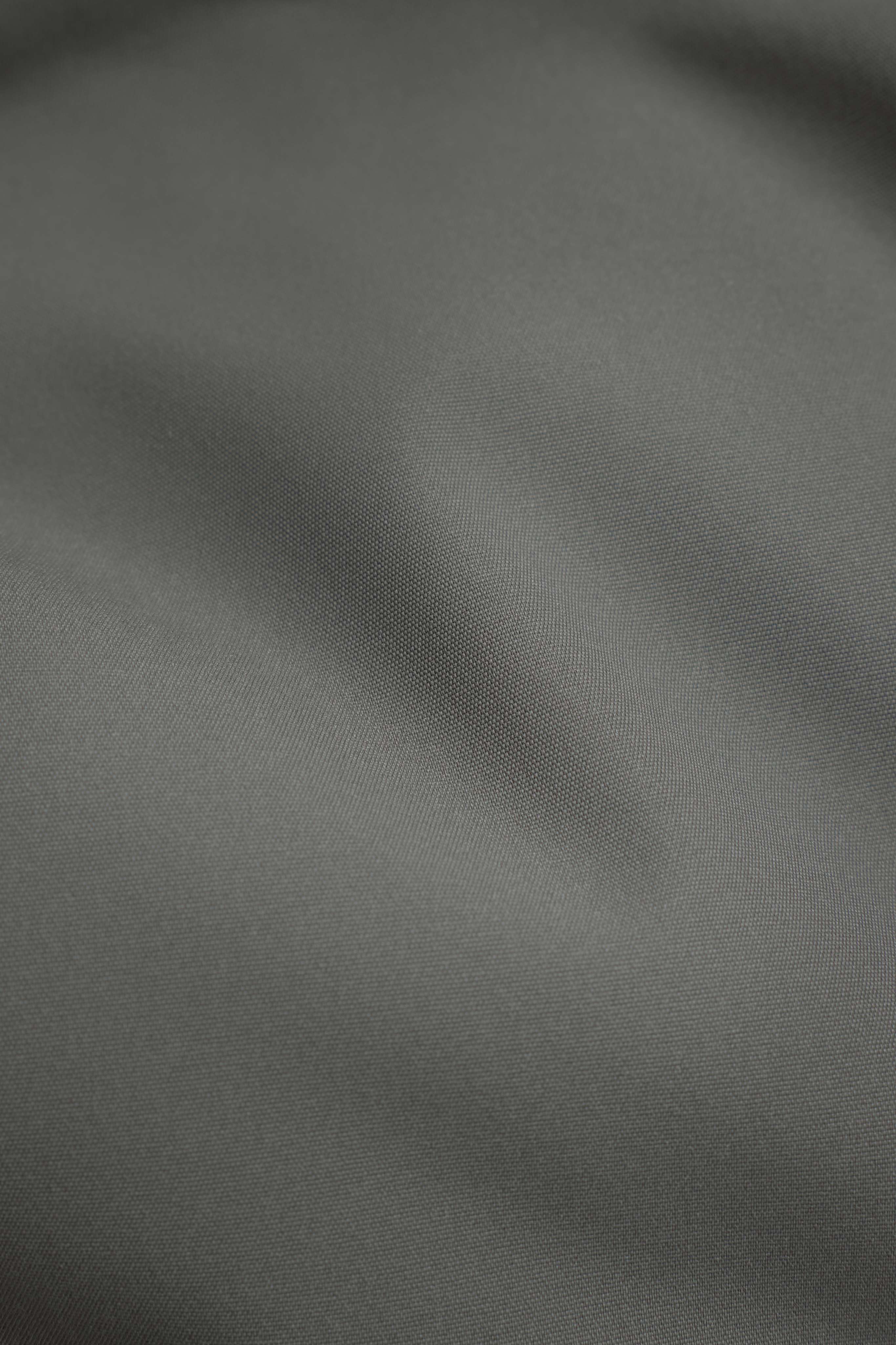 Close-up of the textured khaki fabric on the CASPARA Boreal Puffer Jacket.