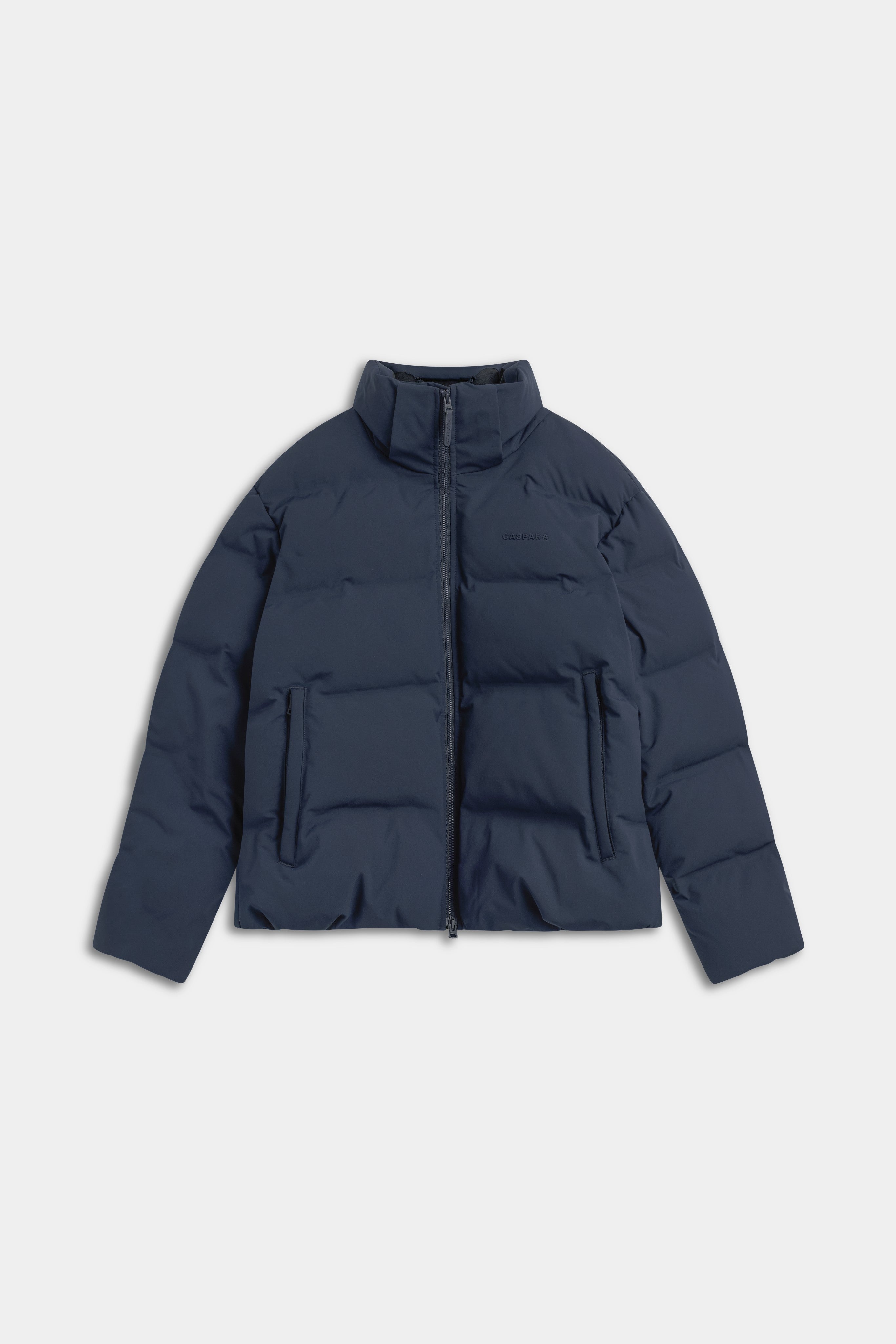 Front view of the navy CASPARA Aurora puffer jacket on a light background.