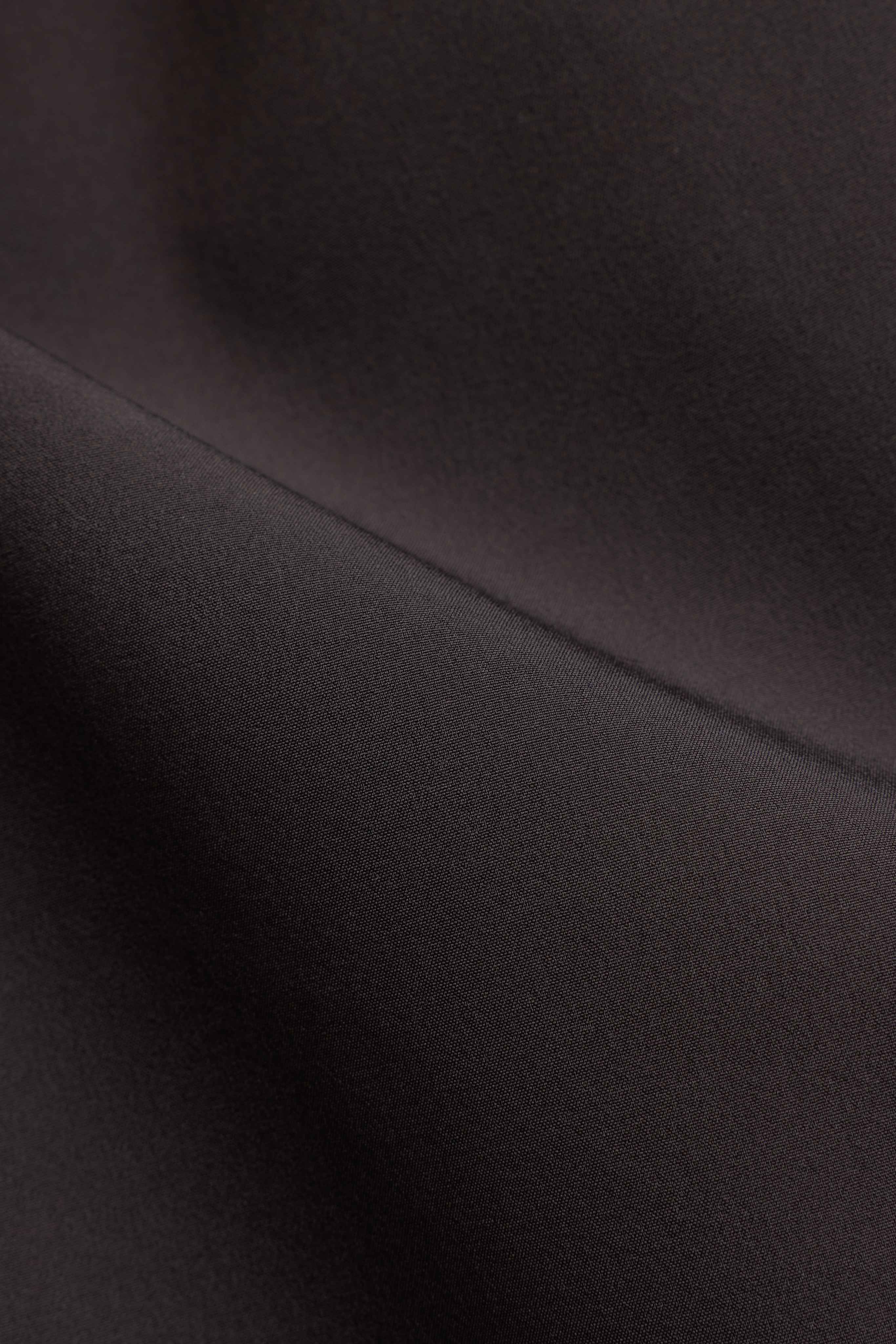 Close-up of the espresso brown stretch fabric on CASPARA Vantage shorts.