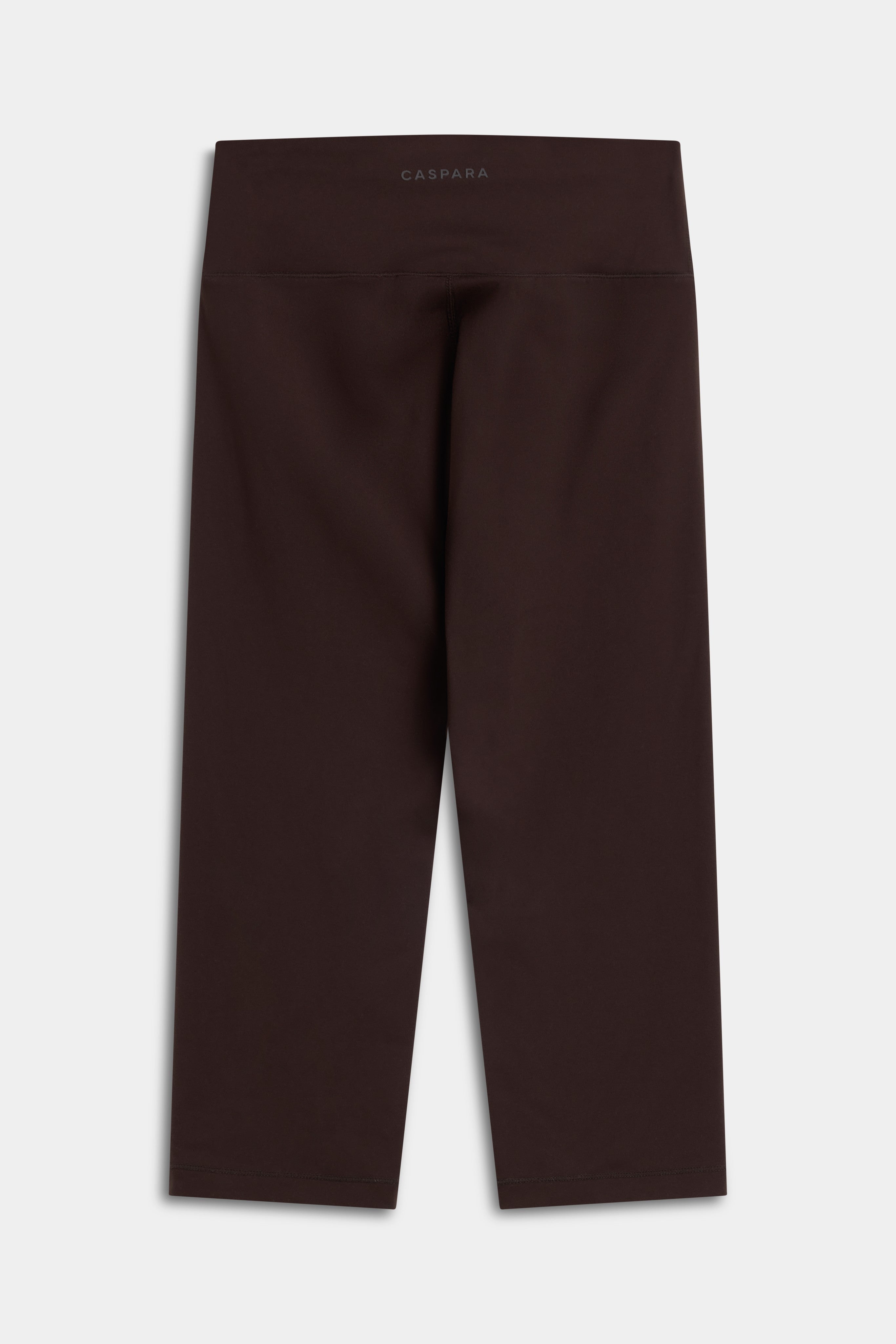 Back view of CASPARA Cloudform capri leggings in espresso brown against a neutral background.