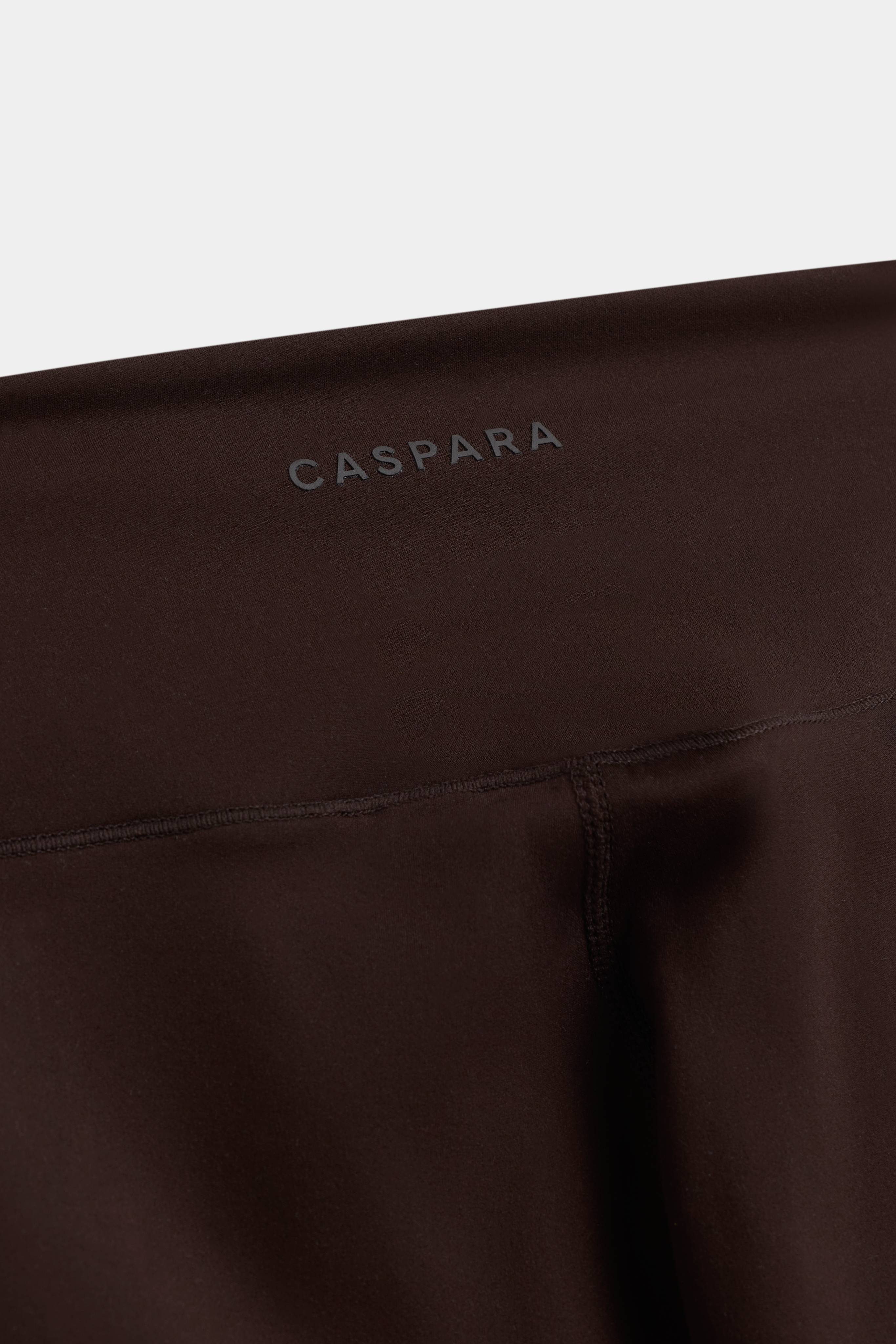 Close-up of the waistband and CASPARA logo on espresso Cloudform capri tights.