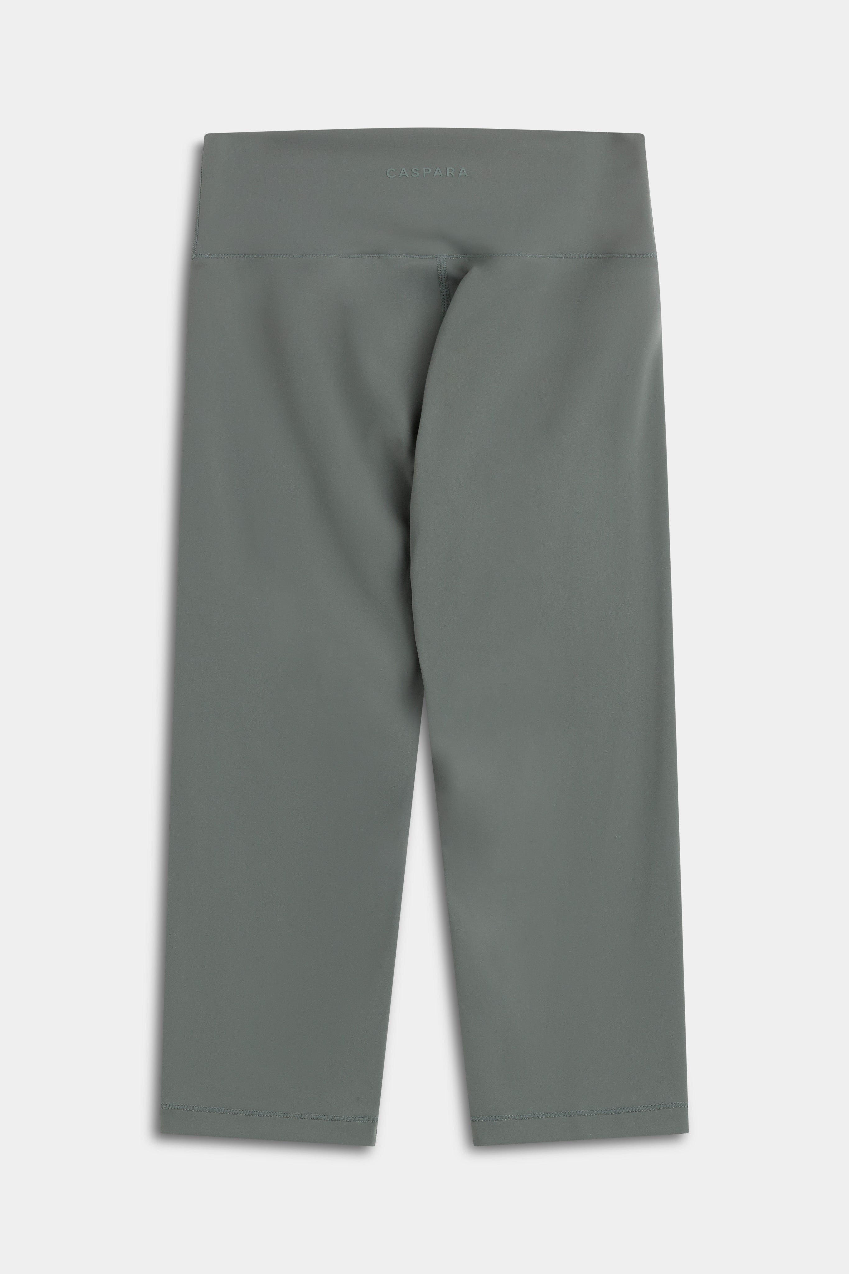Back view of khaki CASPARA Cloudform Capri tights with high-rise waistband and logo.