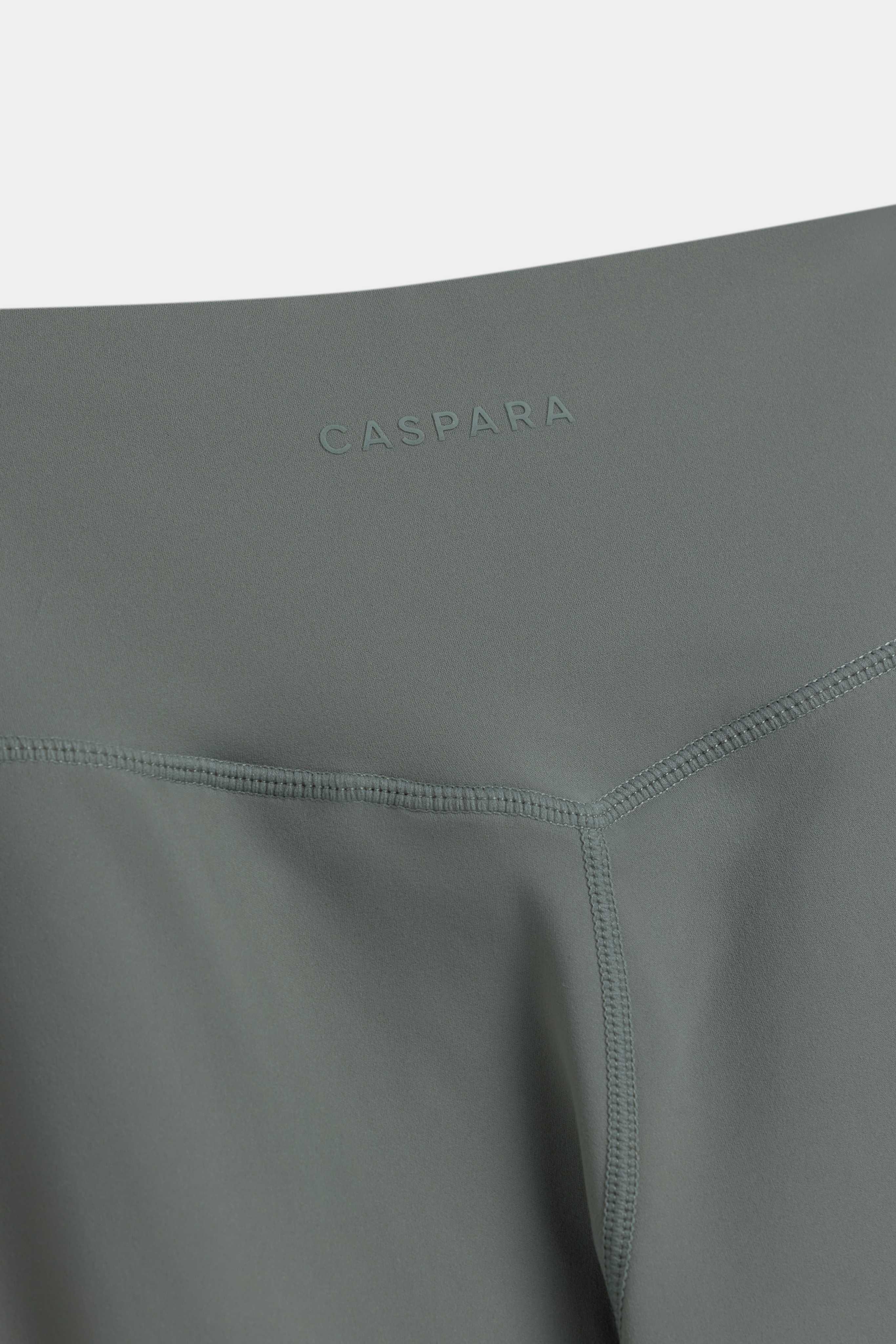 Close-up of the CASPARA logo and V-shaped back seam on khaki Cloudform yoga pants.