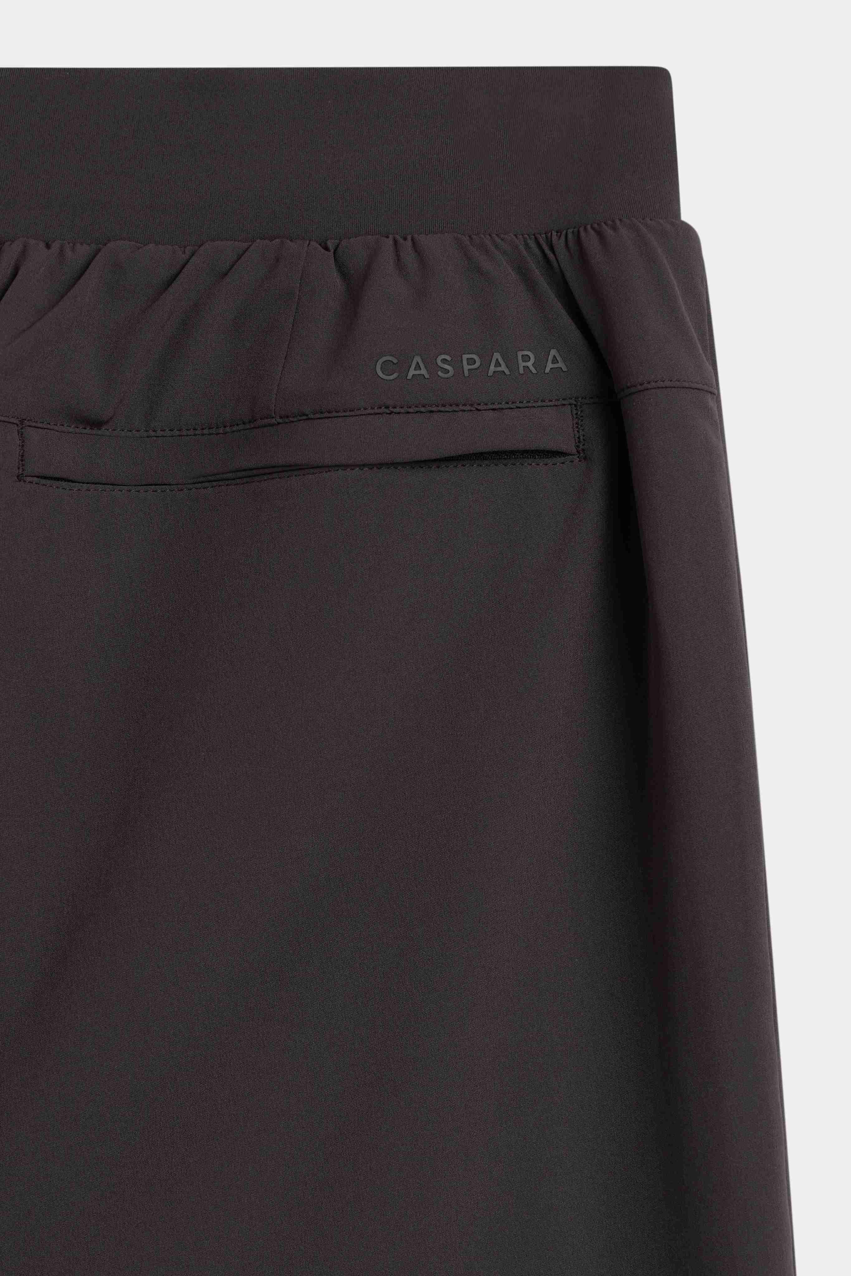Close-up of the waistband and back pocket with logo on espresso CASPARA Prime Core Pants.