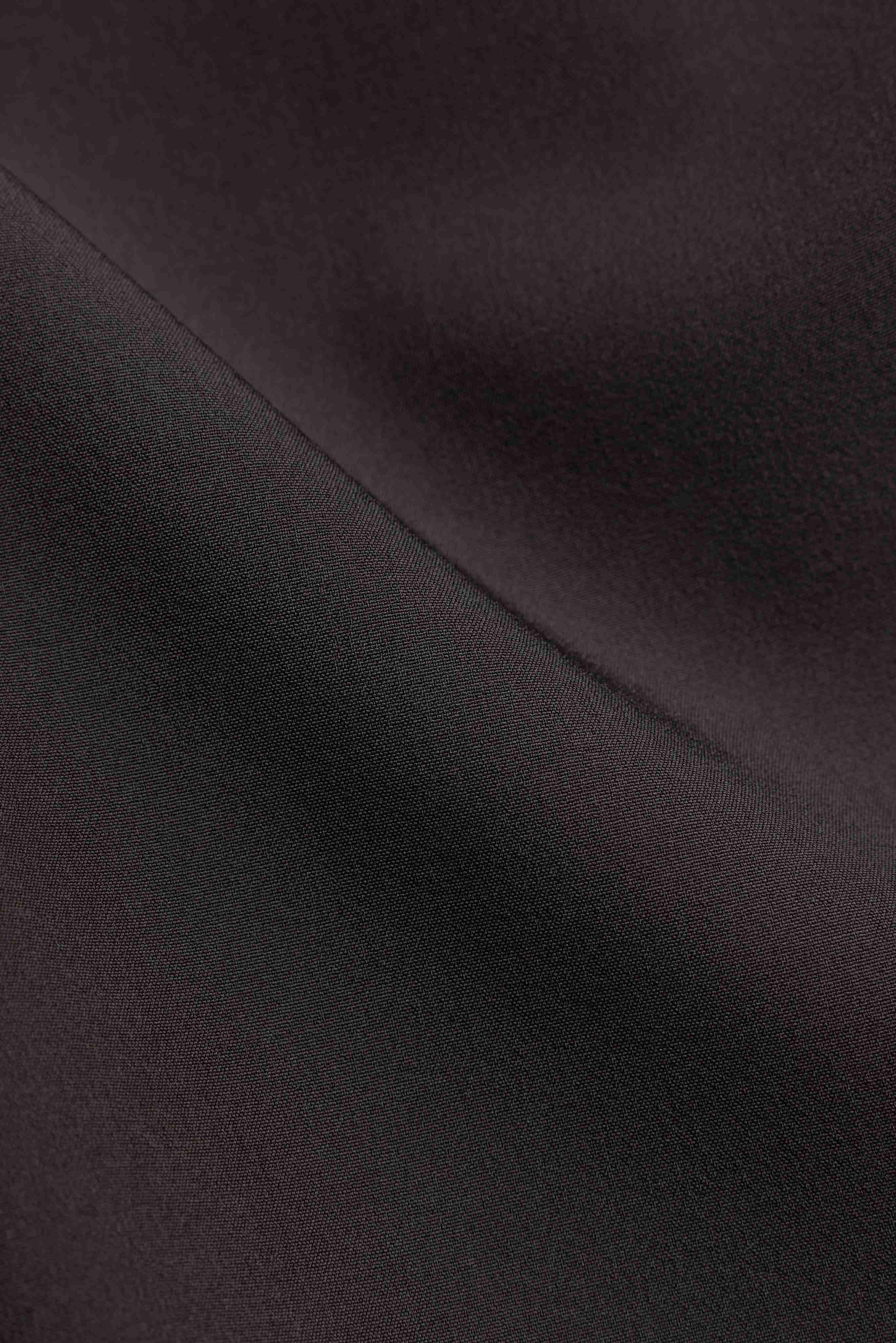 Close-up view of the espresso textured fabric on the CASPARA Prime Core Pants.
