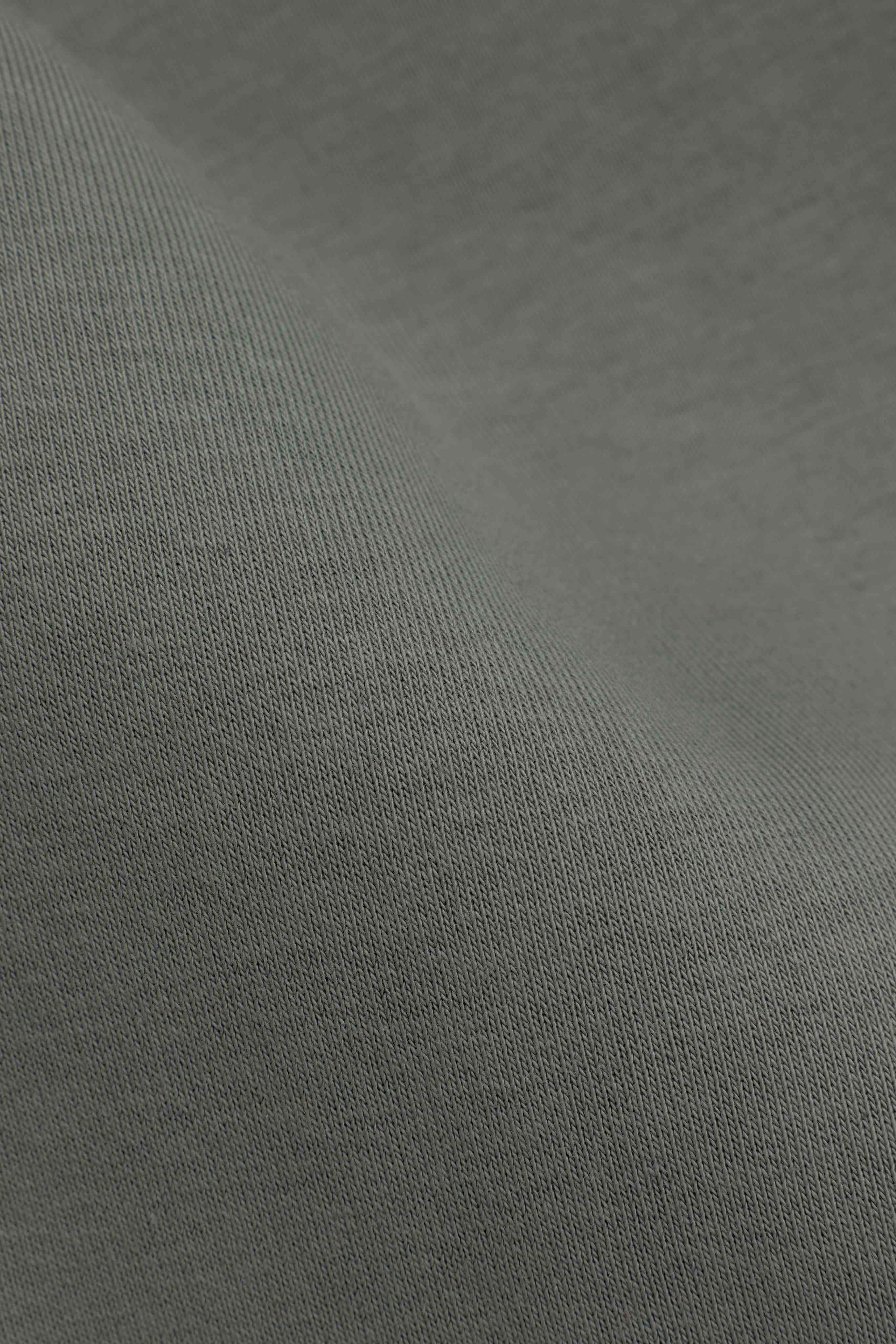 Close-up of the smooth knit fabric texture on the CASPARA khaki sweatpants.