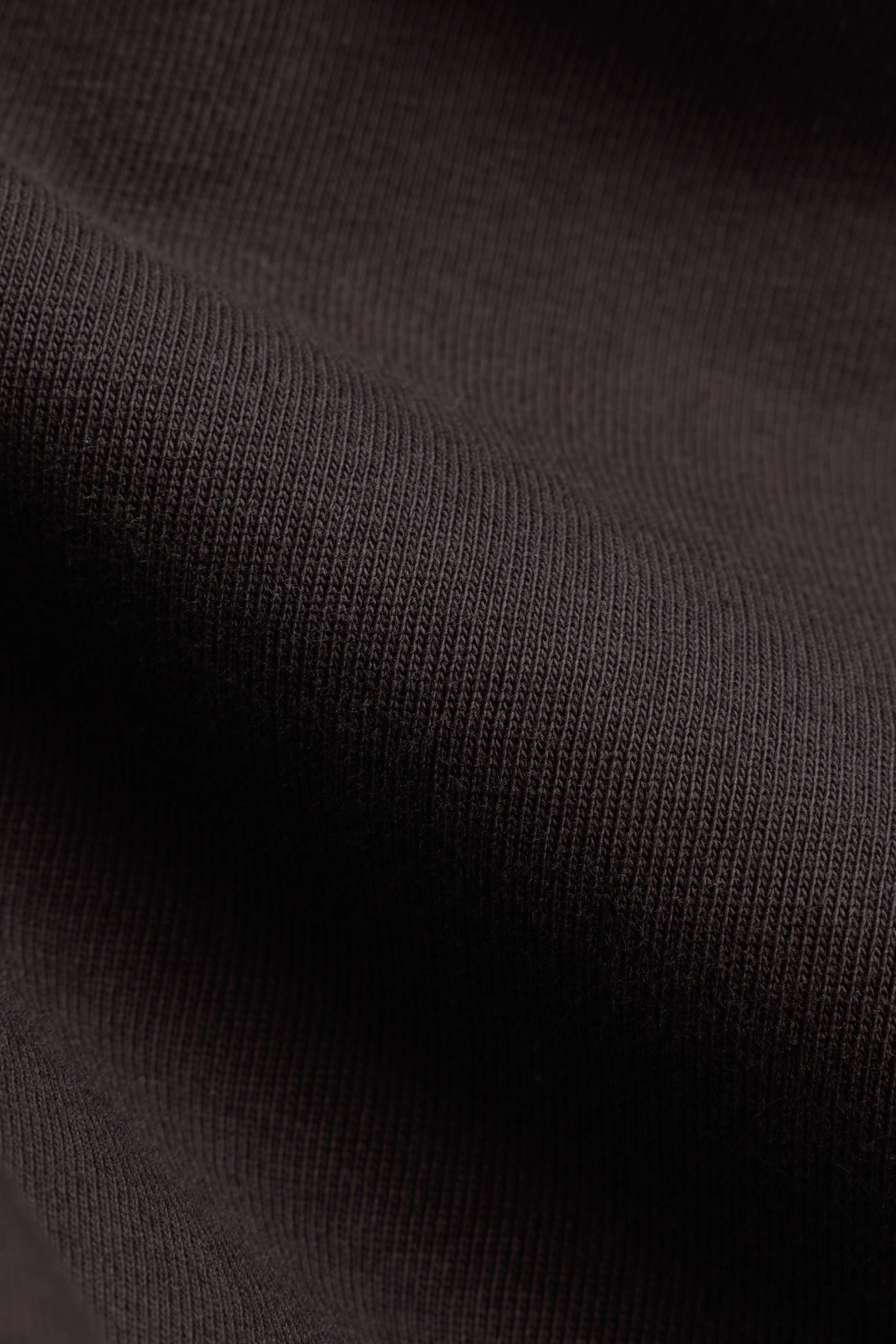 Close-up of espresso brown cotton fabric texture on a CASPARA CS Signature long sleeve.