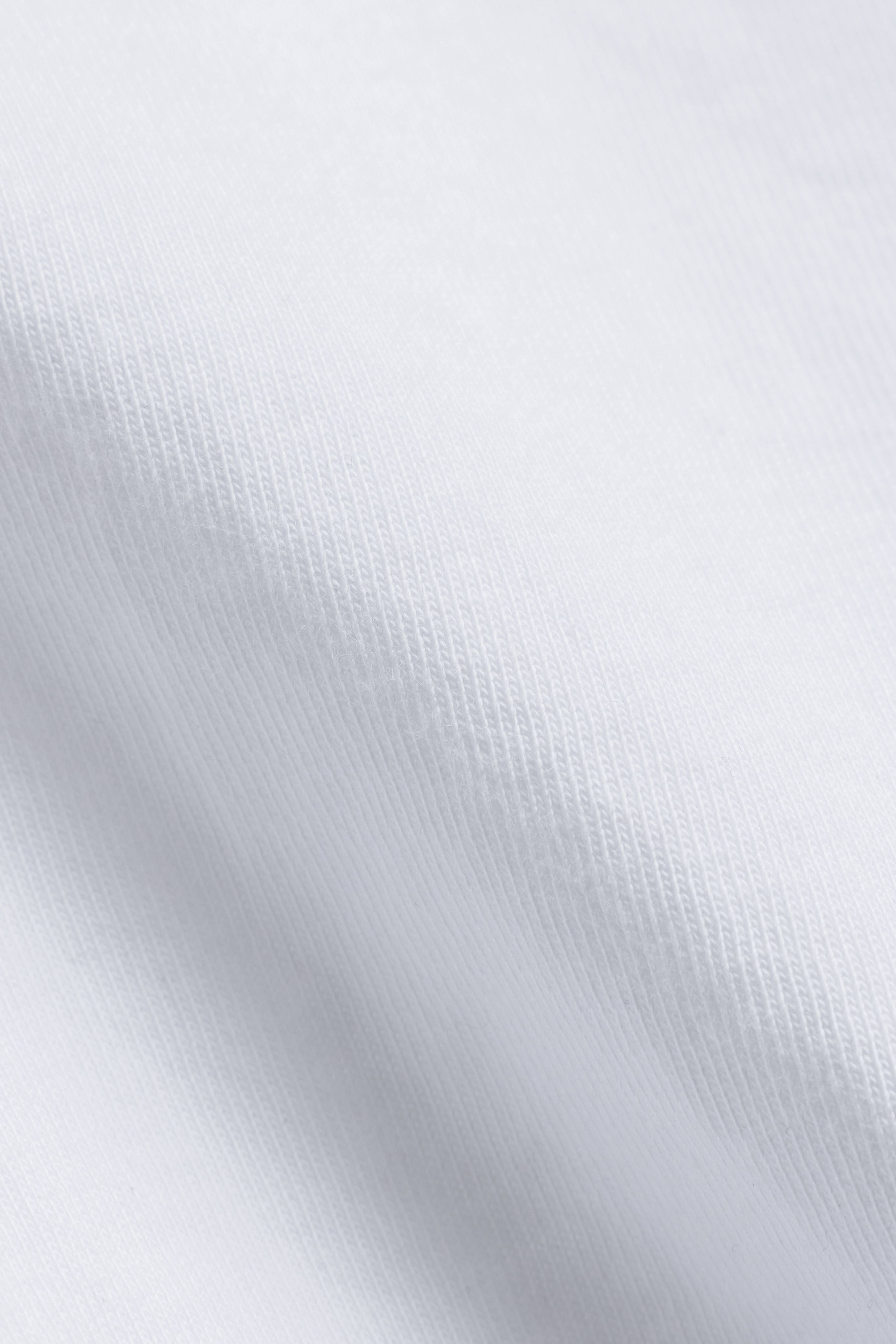 Close-up texture of the white cotton fabric on a CASPARA CS Signature long sleeve shirt.