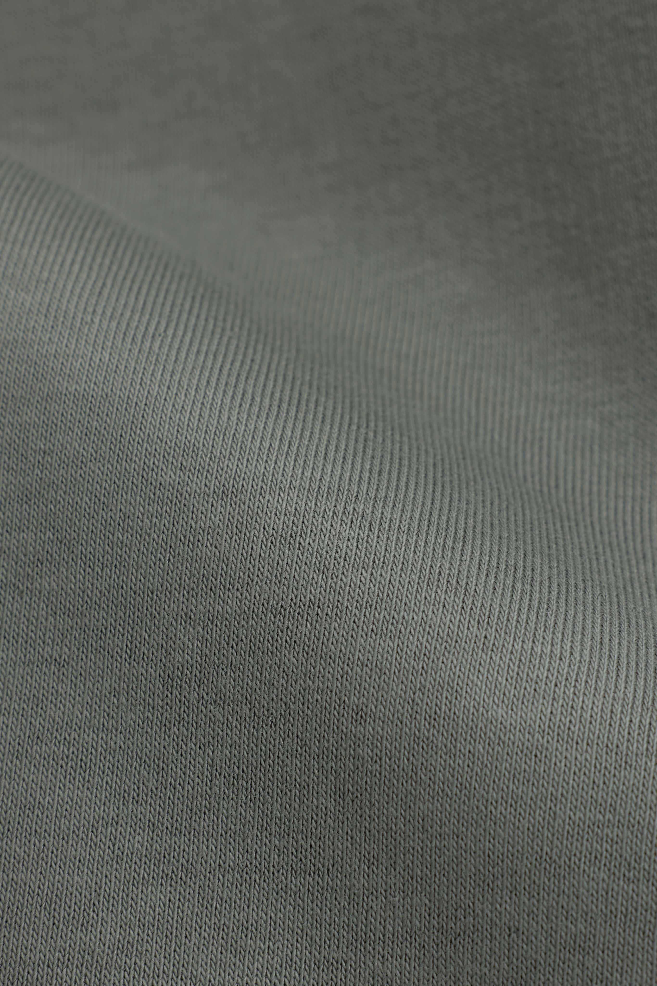 Close-up of the soft khaki fabric texture on the CASPARA CS Crewneck.