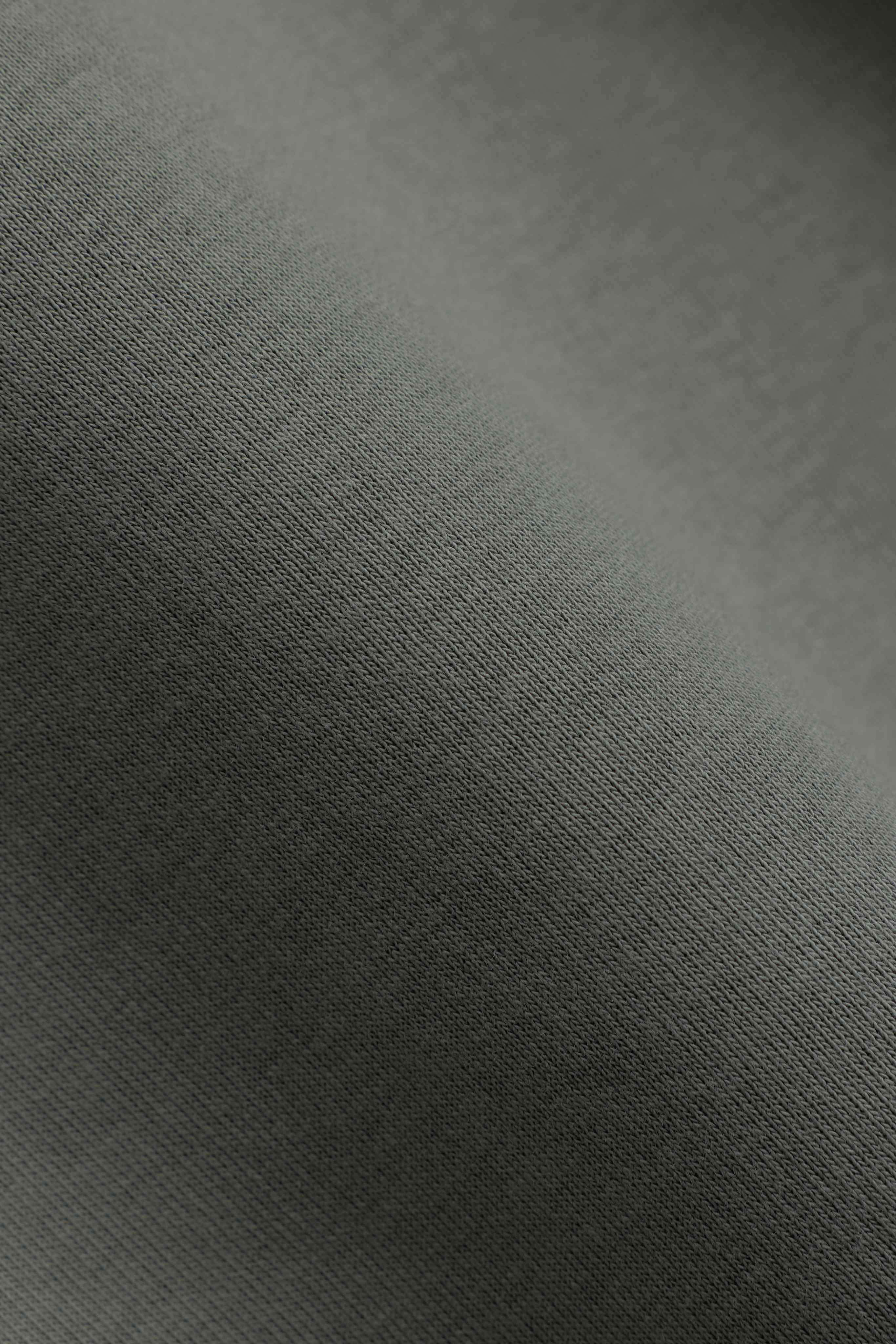 Close-up of the fine knit khaki fabric on the CASPARA CS rugby shirt.