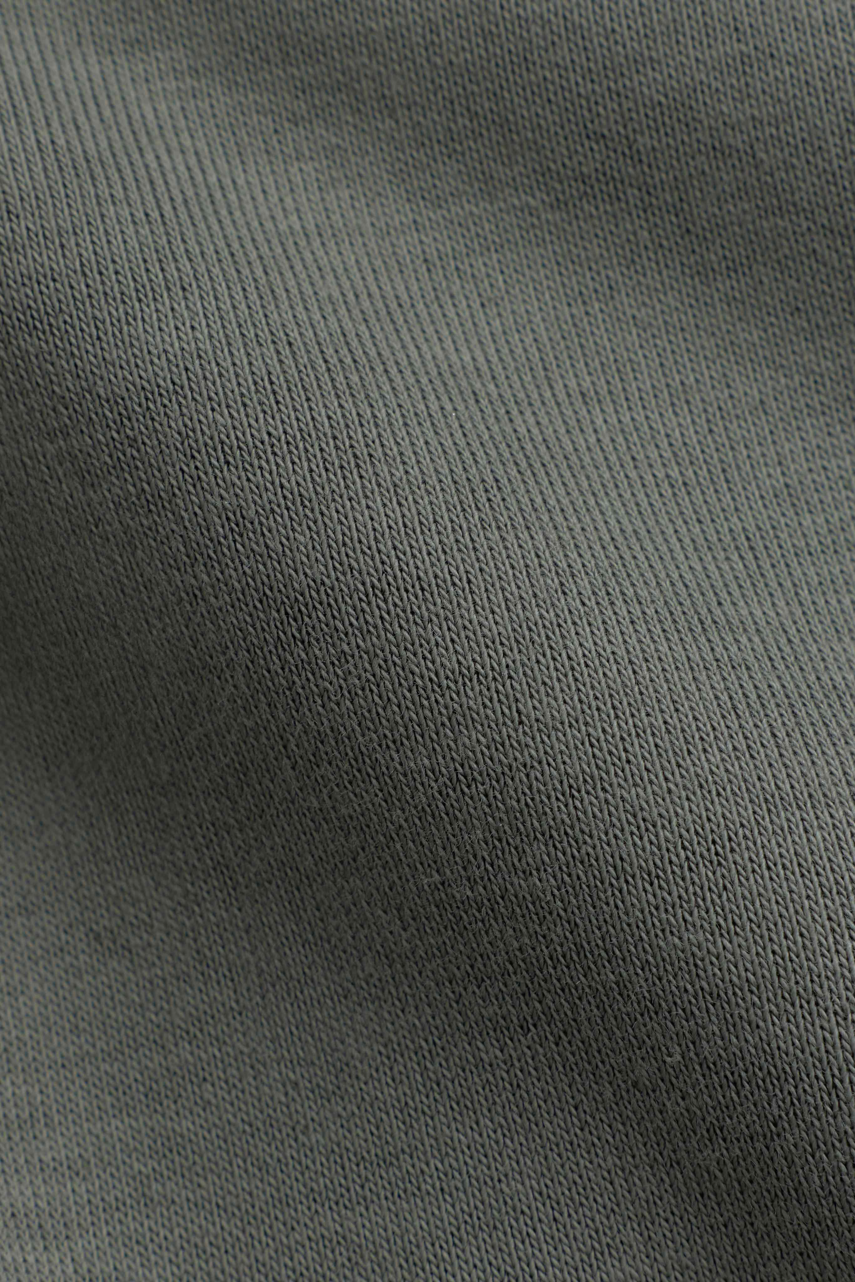 Close-up of the soft khaki fabric texture on the CASPARA CS zip hoodie.