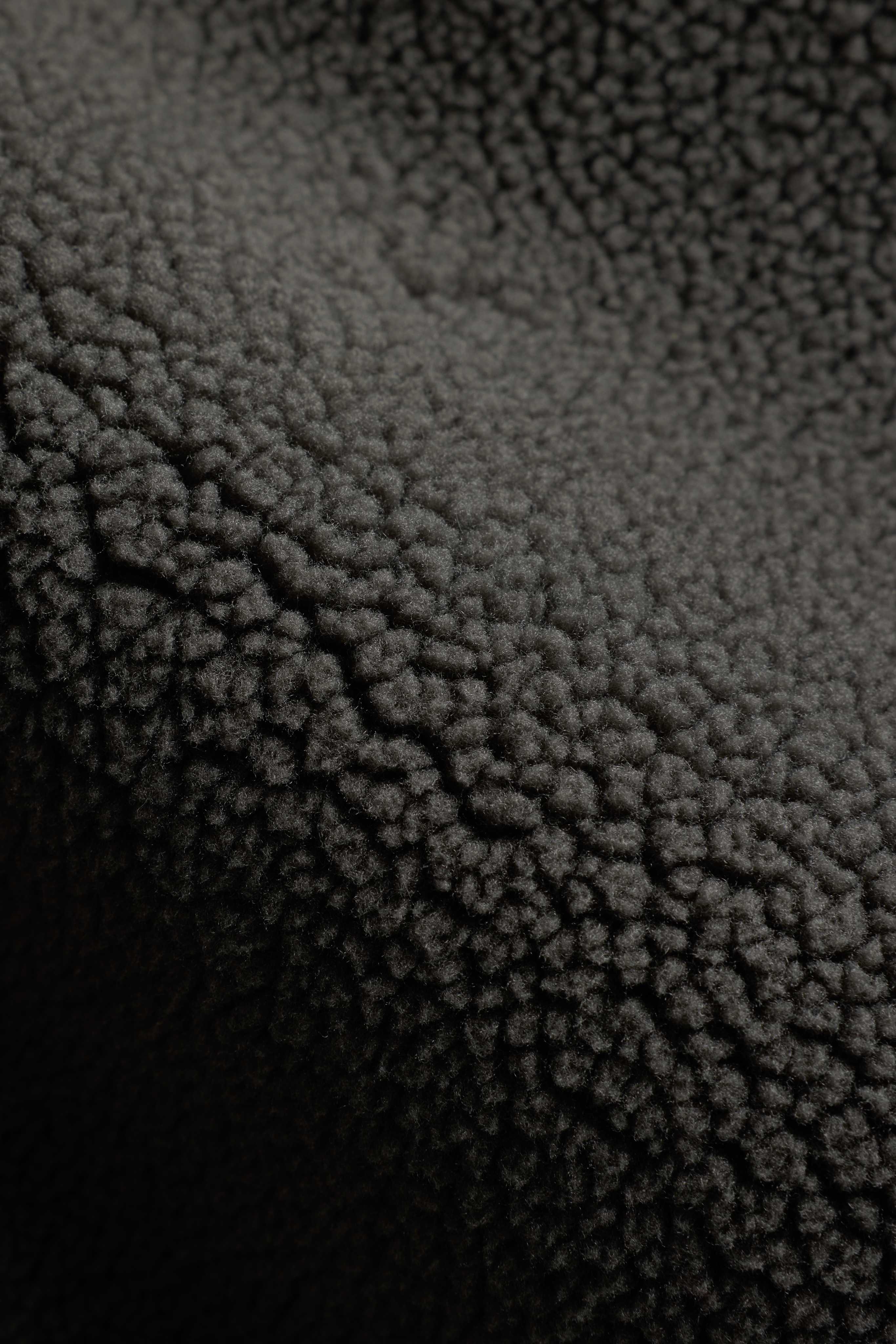 Close-up of the textured khaki fleece fabric on a CASPARA Cloudfleece jacket.