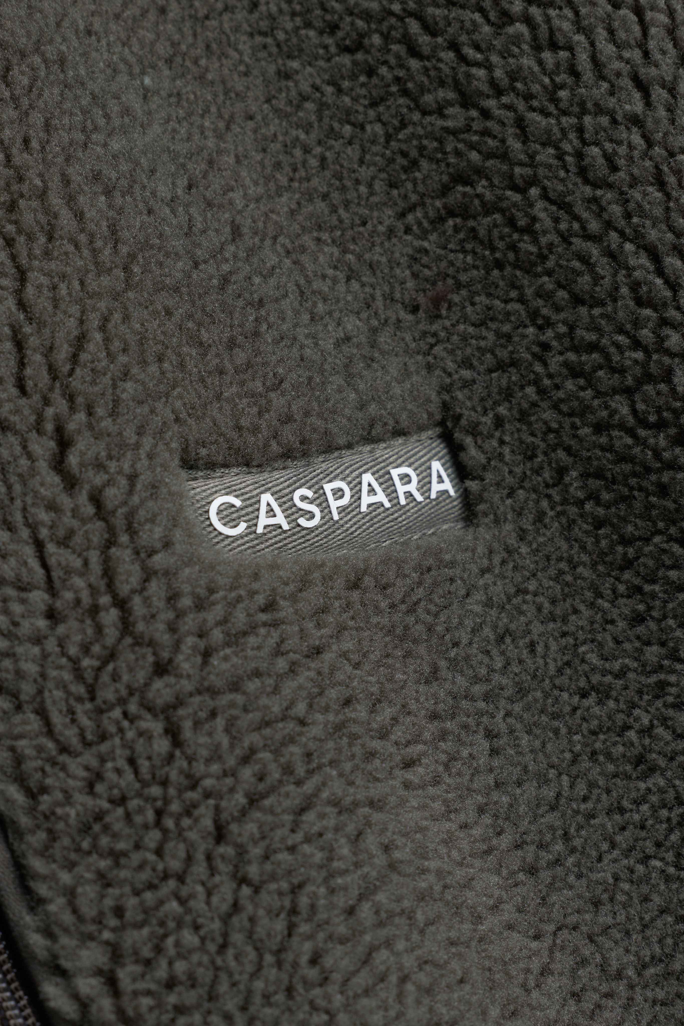 Close-up of the textured khaki fleece featuring a CASPARA logo label.