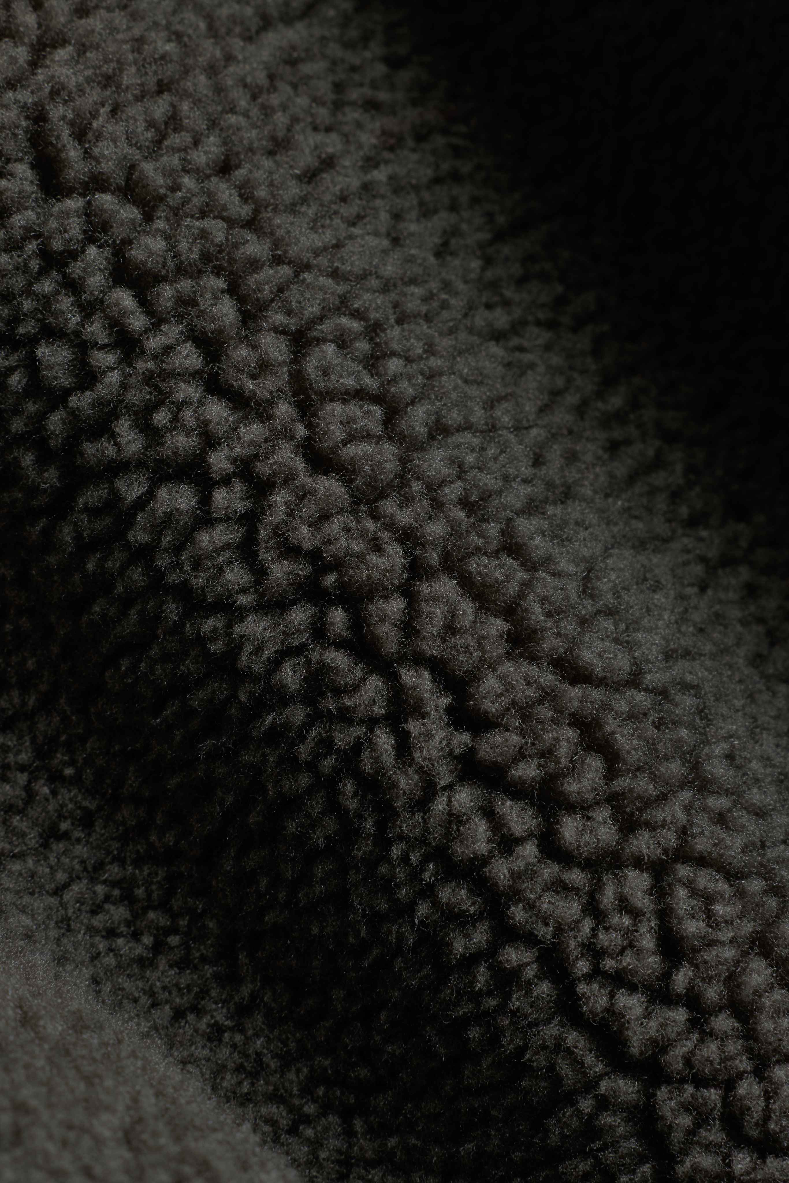 Close-up of the textured khaki fleece fabric on a CASPARA Cloudfleece jacket.