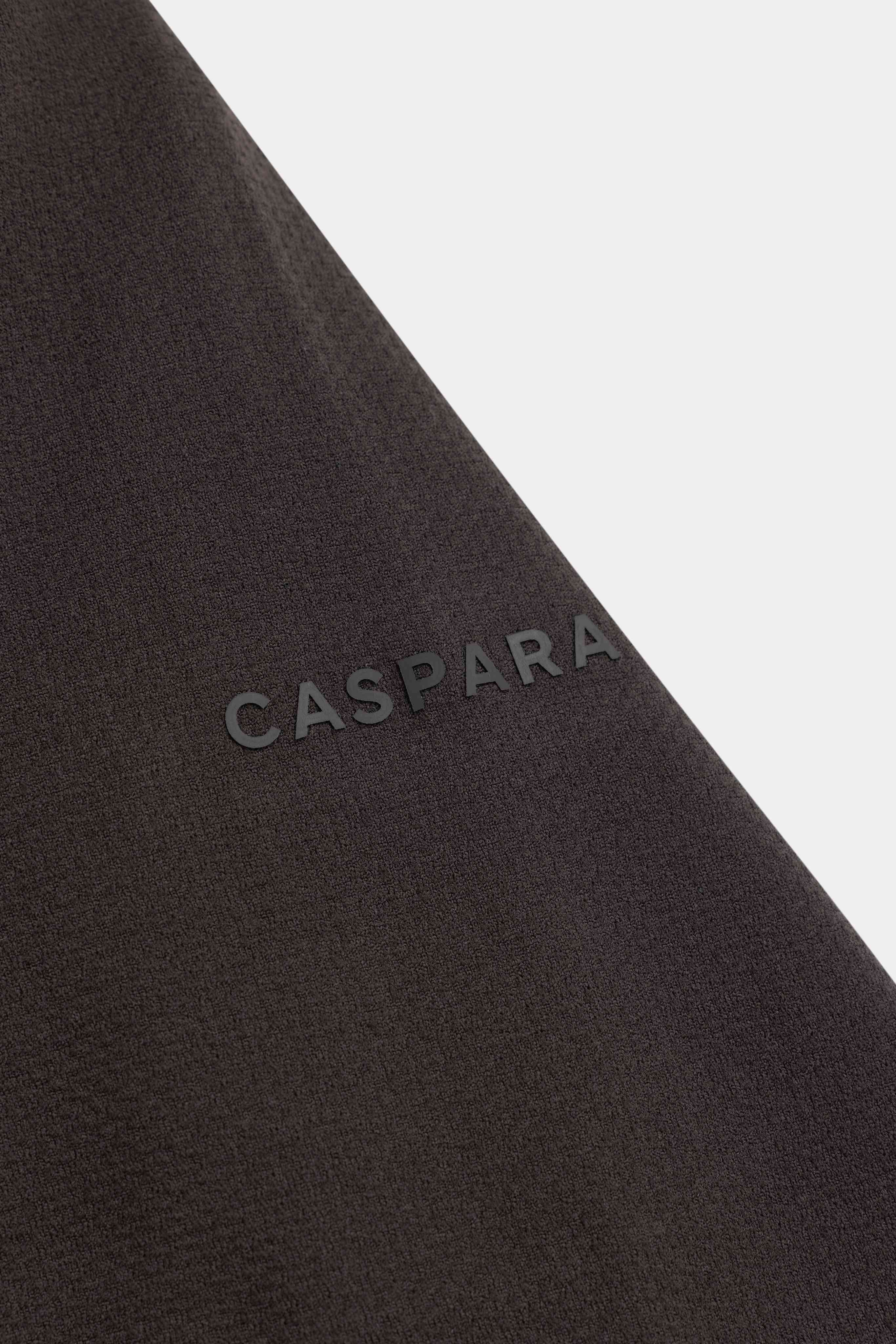 Close-up of the tonal CASPARA logo detail on an espresso brown Seamlite tee.