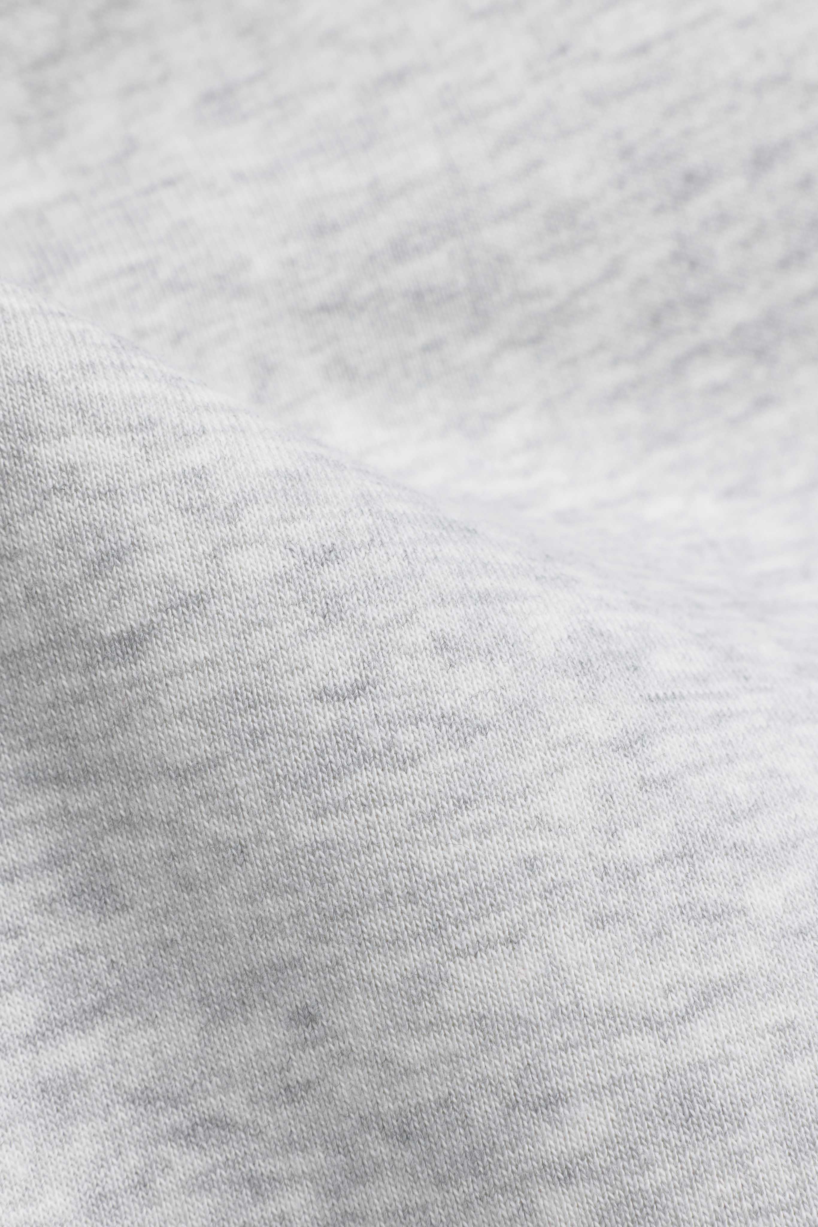 Close-up of textured grey melange cotton fabric on CASPARA sweatpants.