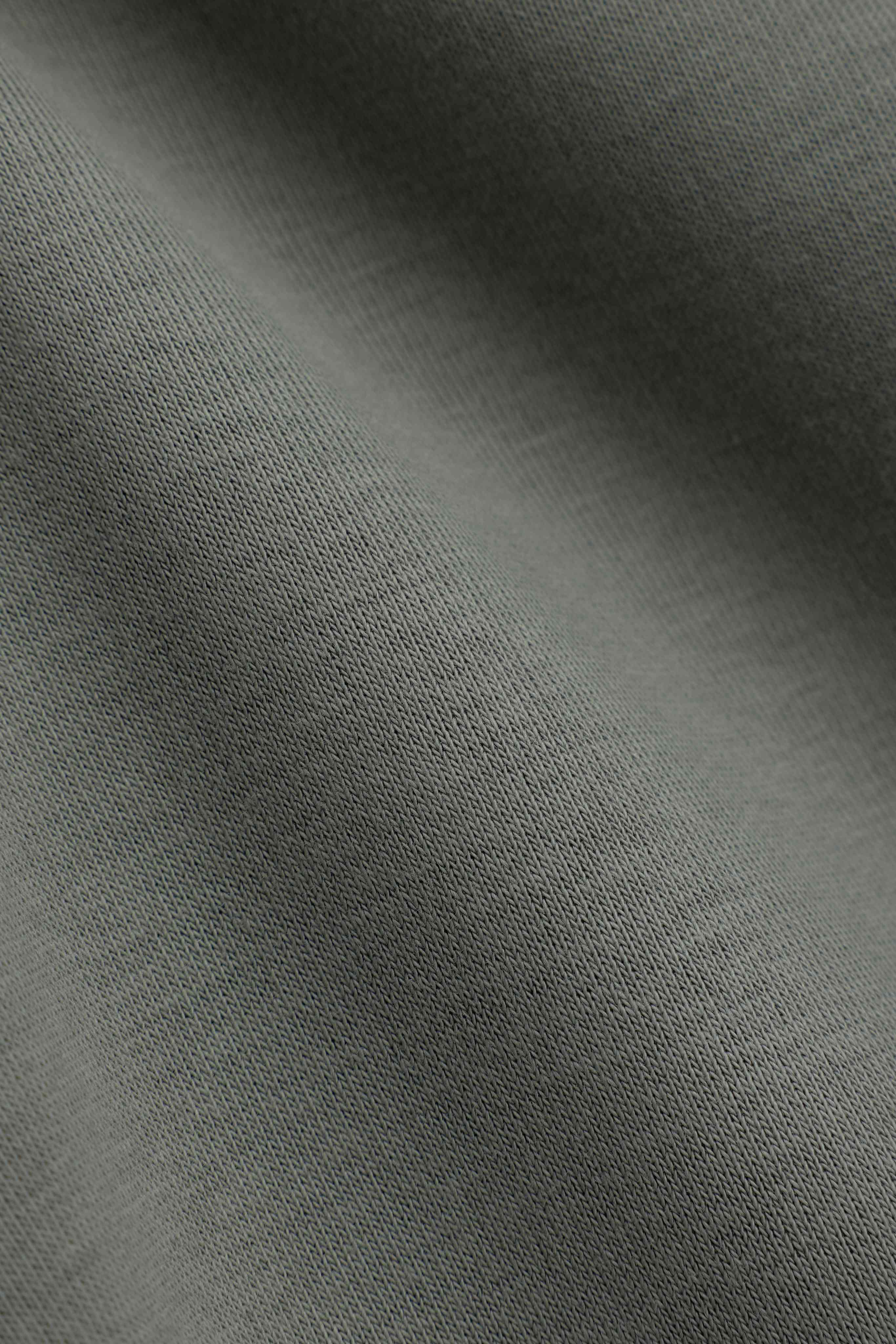 Close-up of the heavyweight khaki fabric texture on CASPARA CS sweatpants.