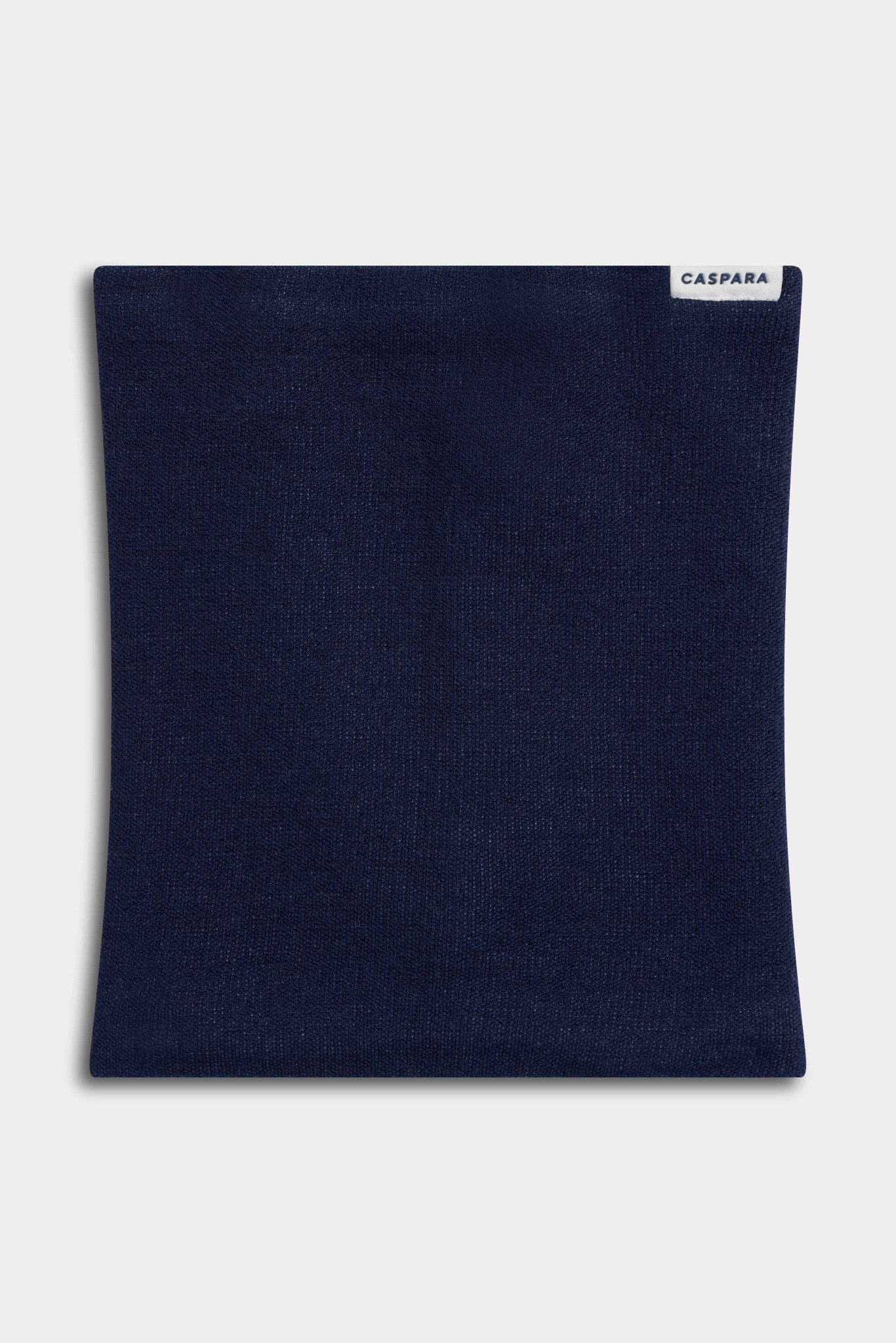 CASPARA Classic Neckwarmer in navy blue knit laid flat against a light grey background.