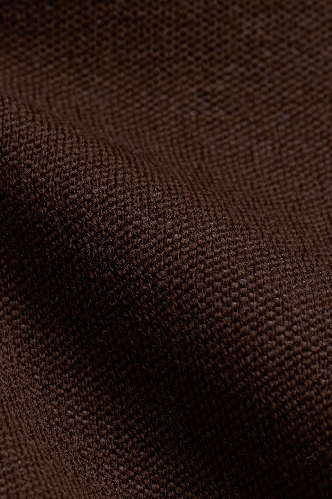 Close-up of the espresso brown wool knit texture on the CASPARA Classic Neckwarmer.