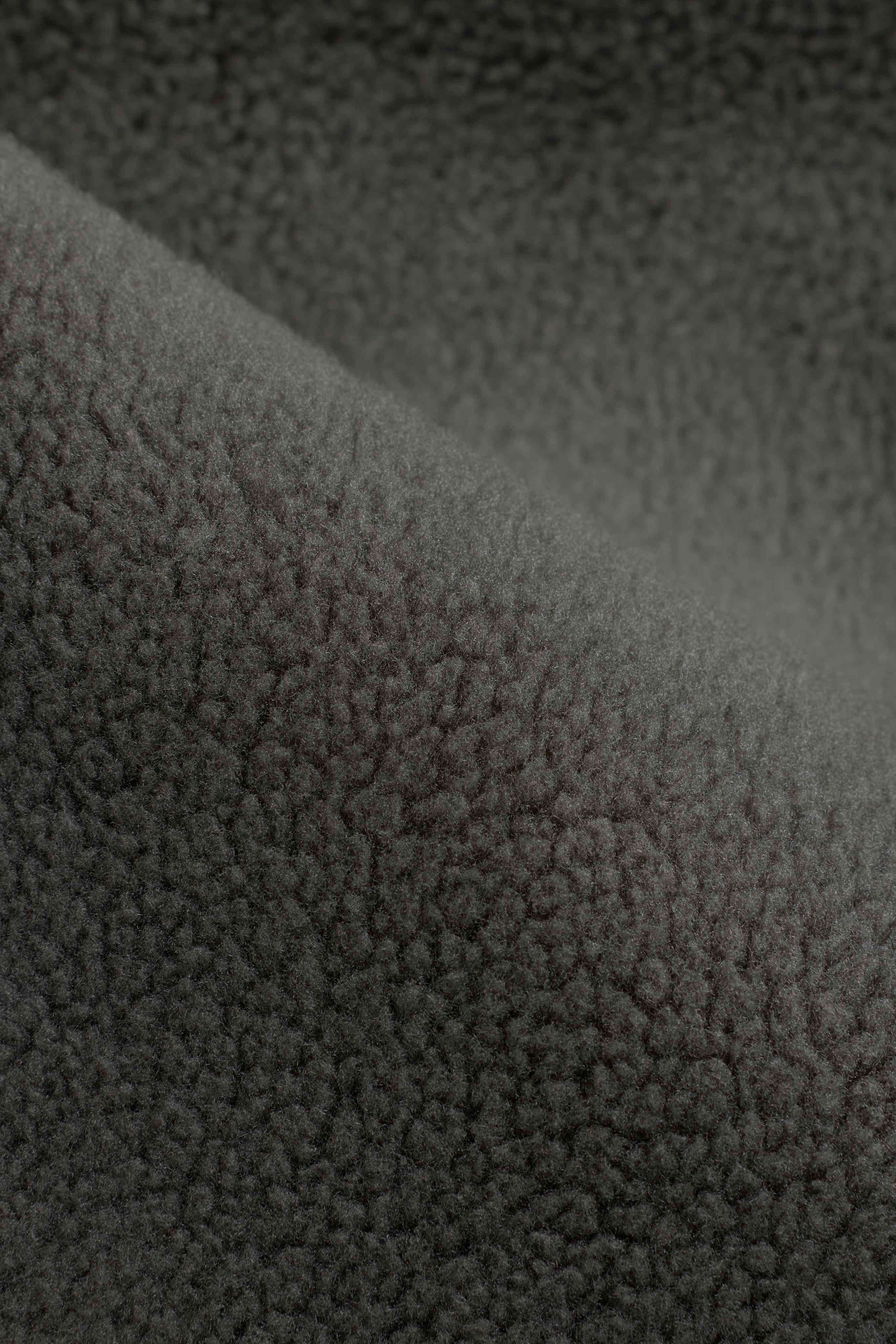 Close-up of the textured khaki fleece material on the CASPARA Cloudfleece vest.