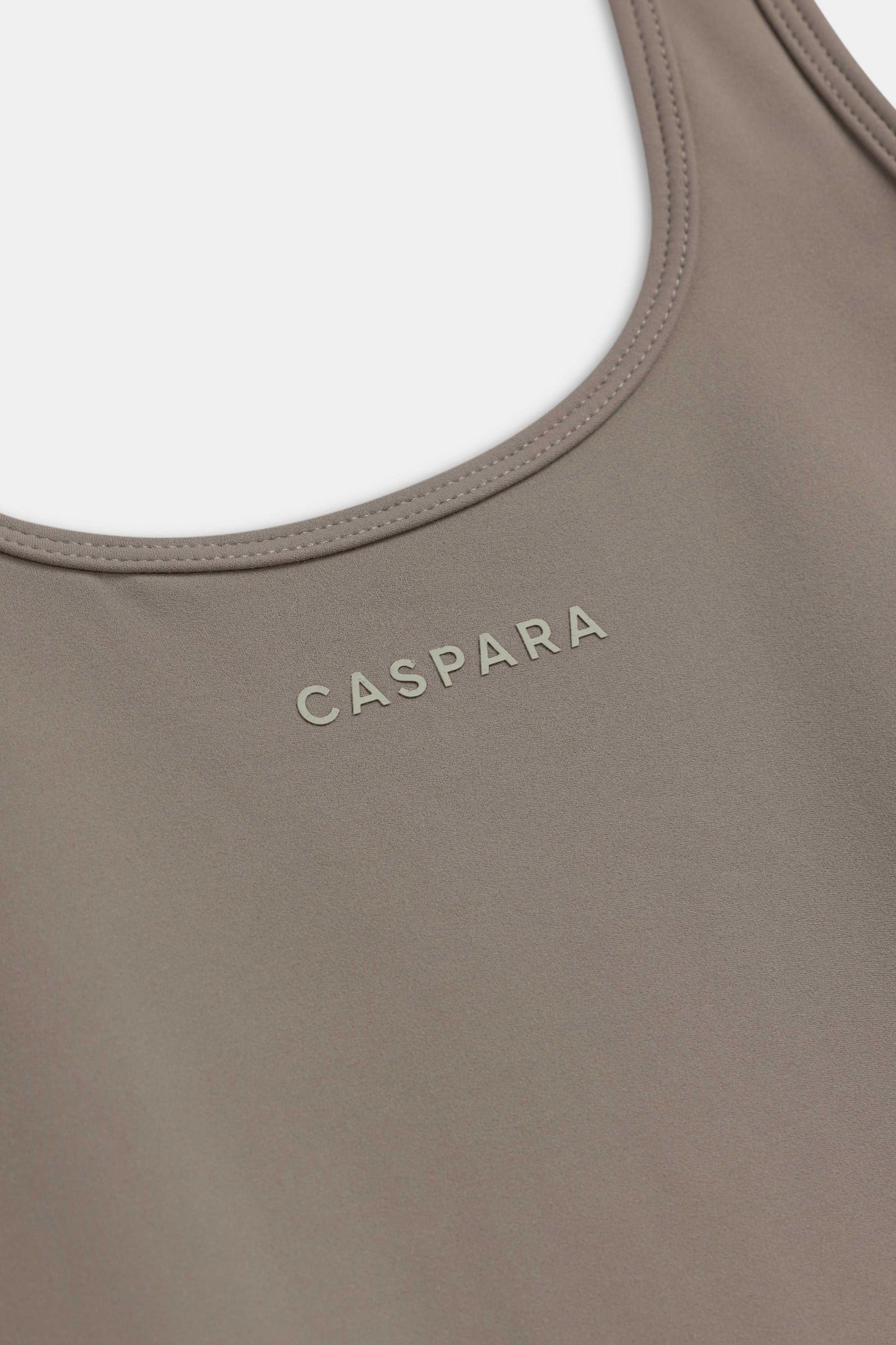 Close-up of the CASPARA logo on the truffle Cloudform square neck top.