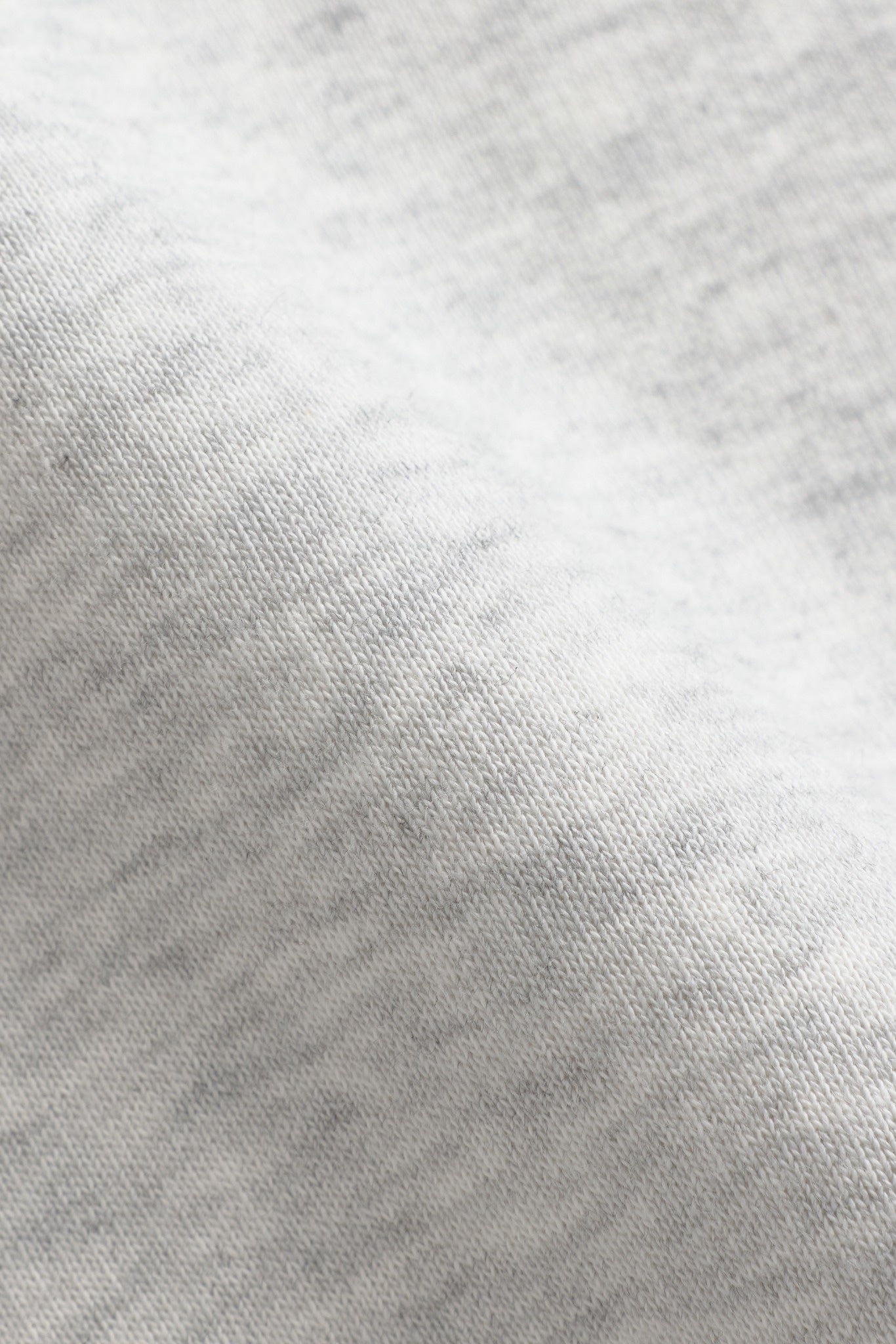 Close-up of the grey melange cotton-blend fabric texture on a CASPARA sweatshirt.