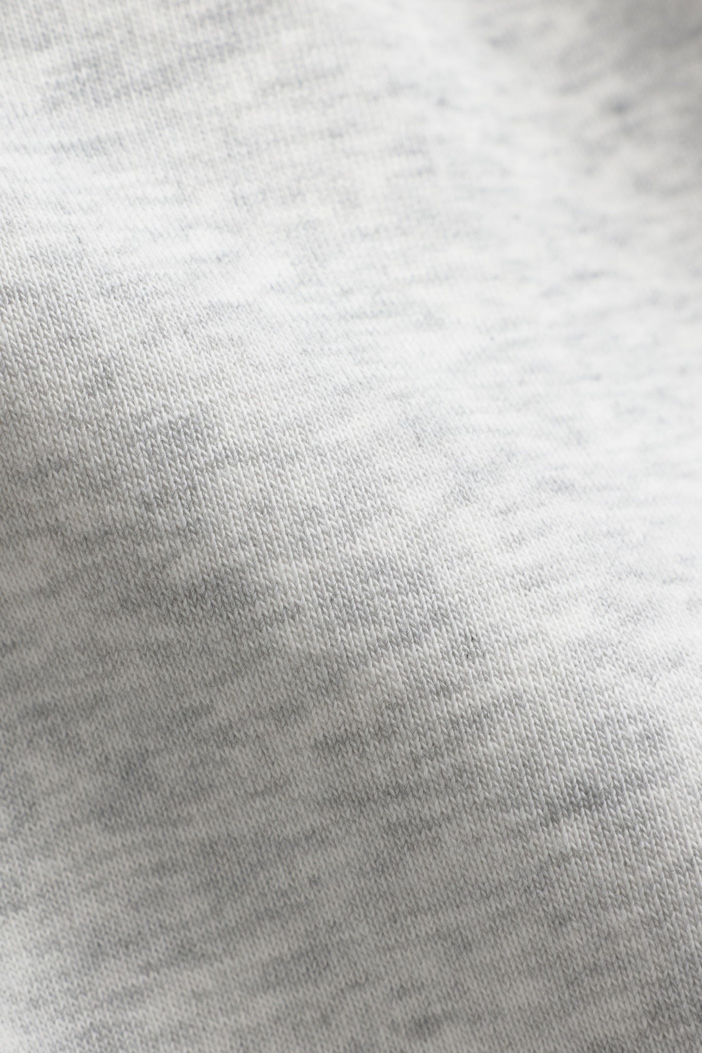 Close-up of grey melange cotton blend fabric texture on the CASPARA All-Star hoodie.