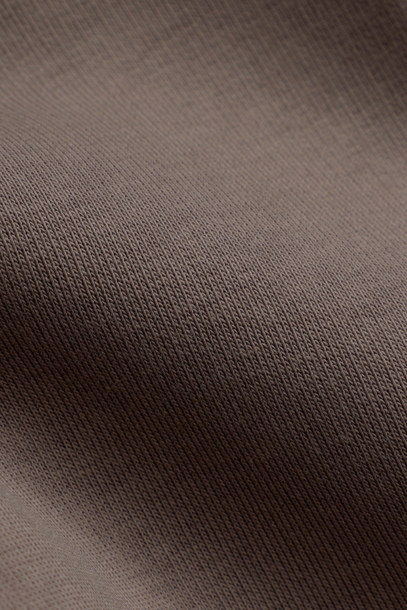 Close-up of the walnut brown cotton-blend fabric texture on the CASPARA All-Star Hoodie.