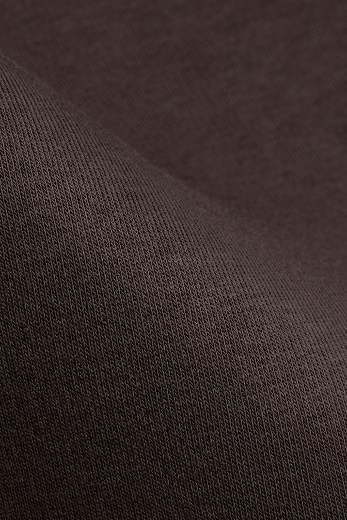 Close-up of espresso brown heavyweight cotton knit fabric on CASPARA All-Star pants.