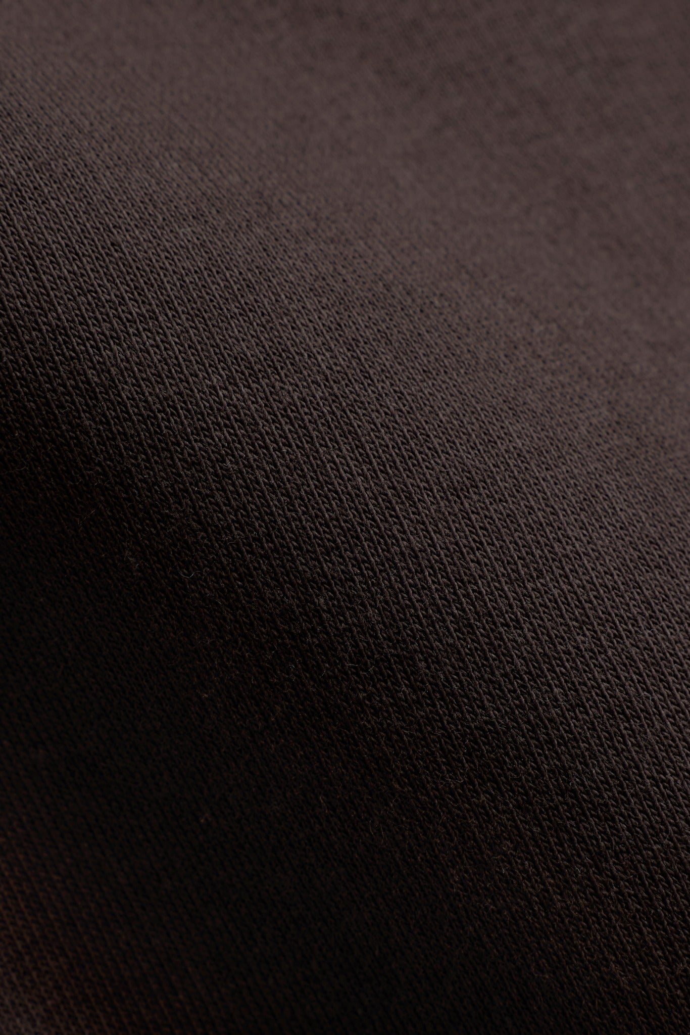 Close-up of espresso brown cotton knit fabric texture on a CASPARA sweatshirt.