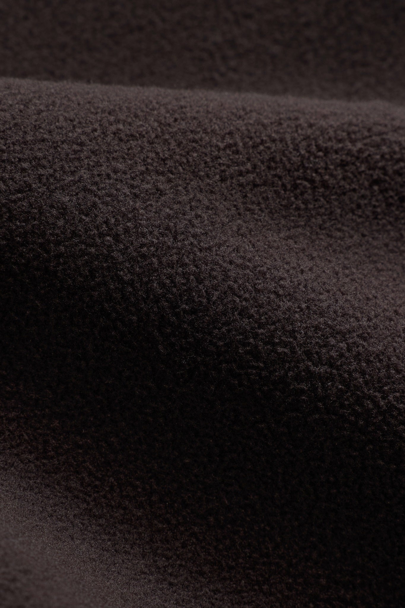 Close-up view of the espresso brown CASPARA polar fleece fabric texture.