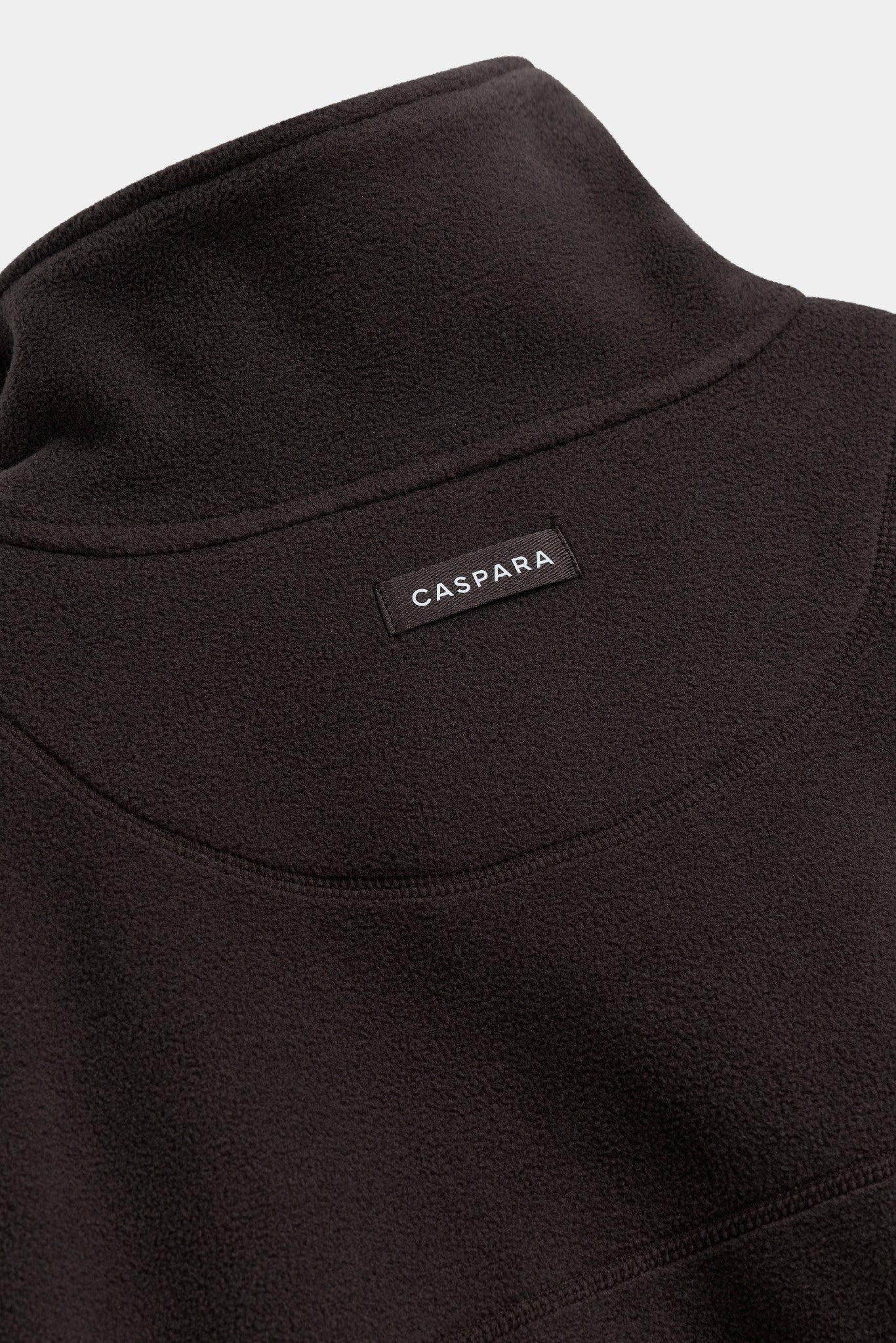 Close-up back view of a cocoa bean CASPARA polar fleece pullover with a woven logo tag.