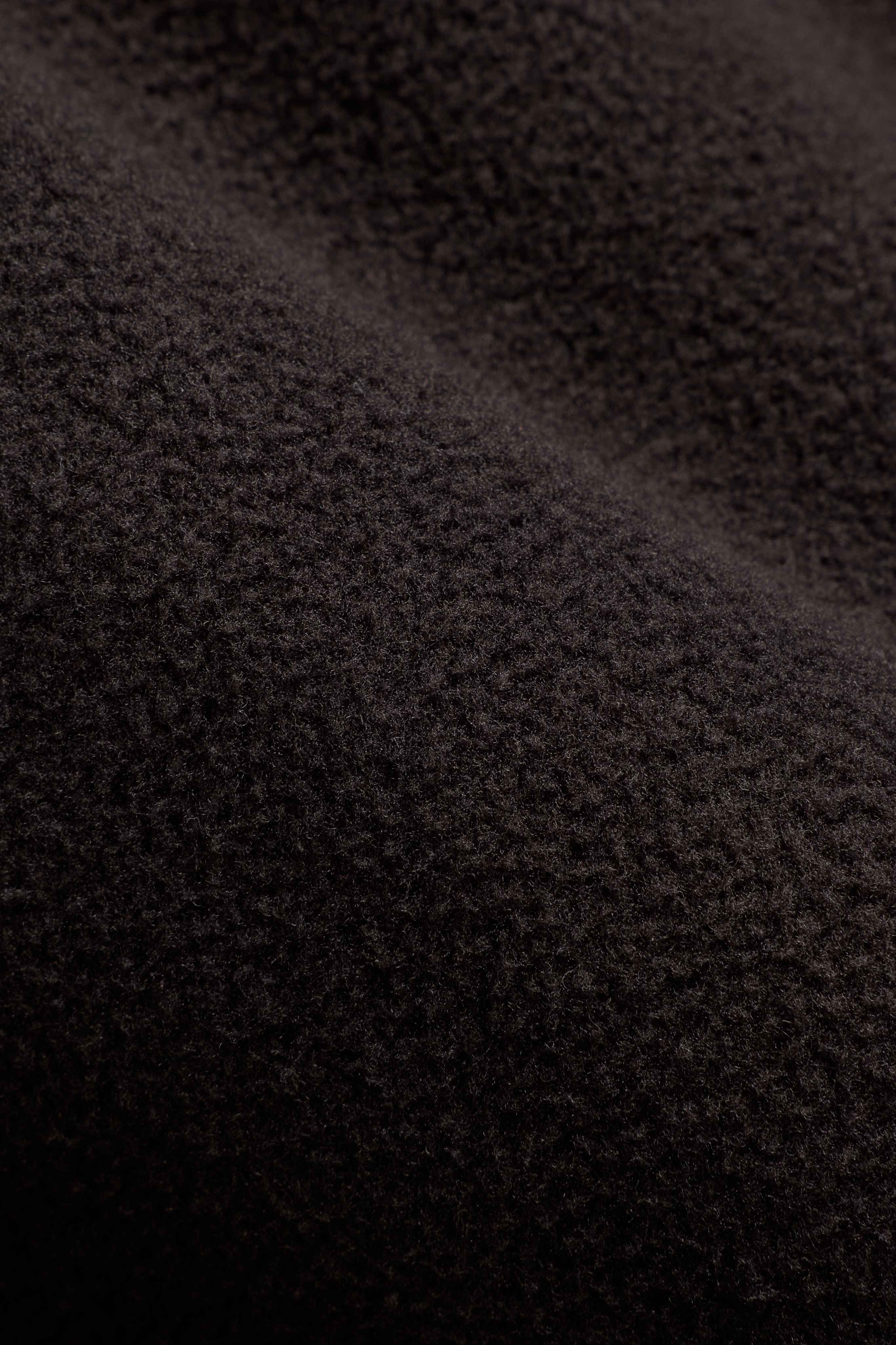 Close-up texture of espresso polar fleece fabric on a CASPARA pullover.