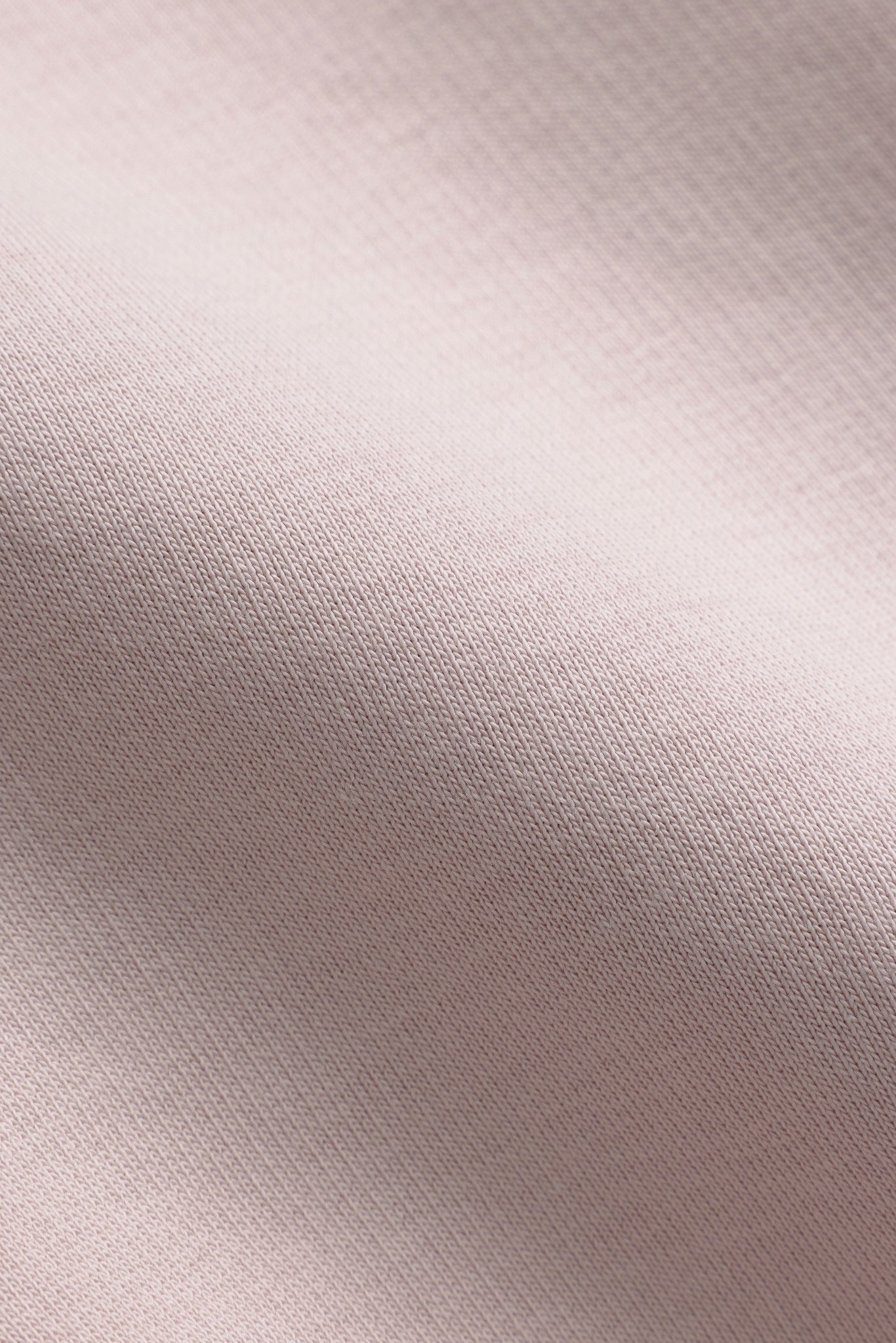 Close-up of dusty pink cotton blend fabric texture on a CASPARA crewneck sweatshirt.