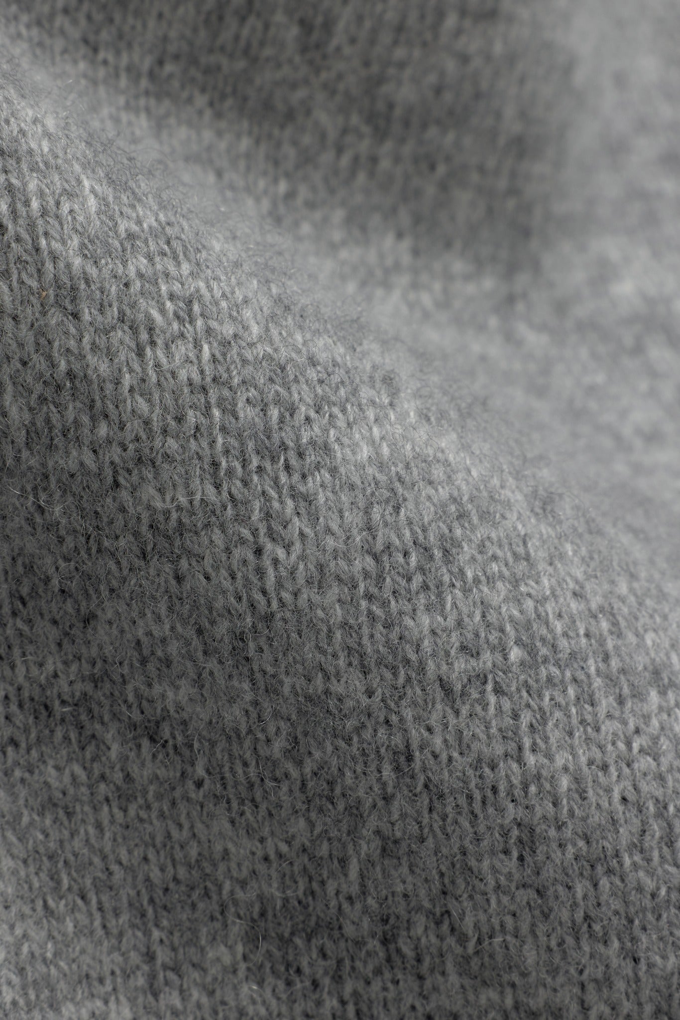 Close-up view of grey 100% wool knit fabric on CASPARA trousers.
