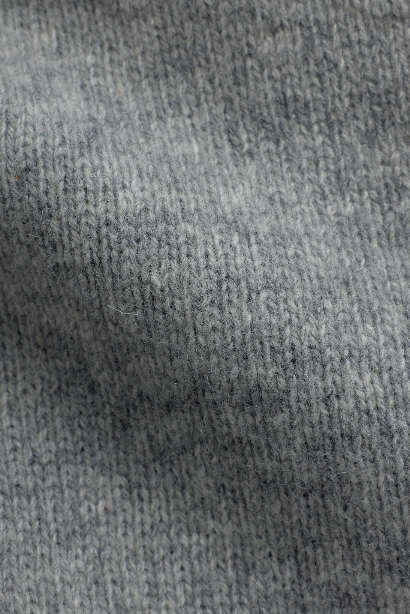 Close-up view of CASPARA dark grey melange wool knit fabric texture.